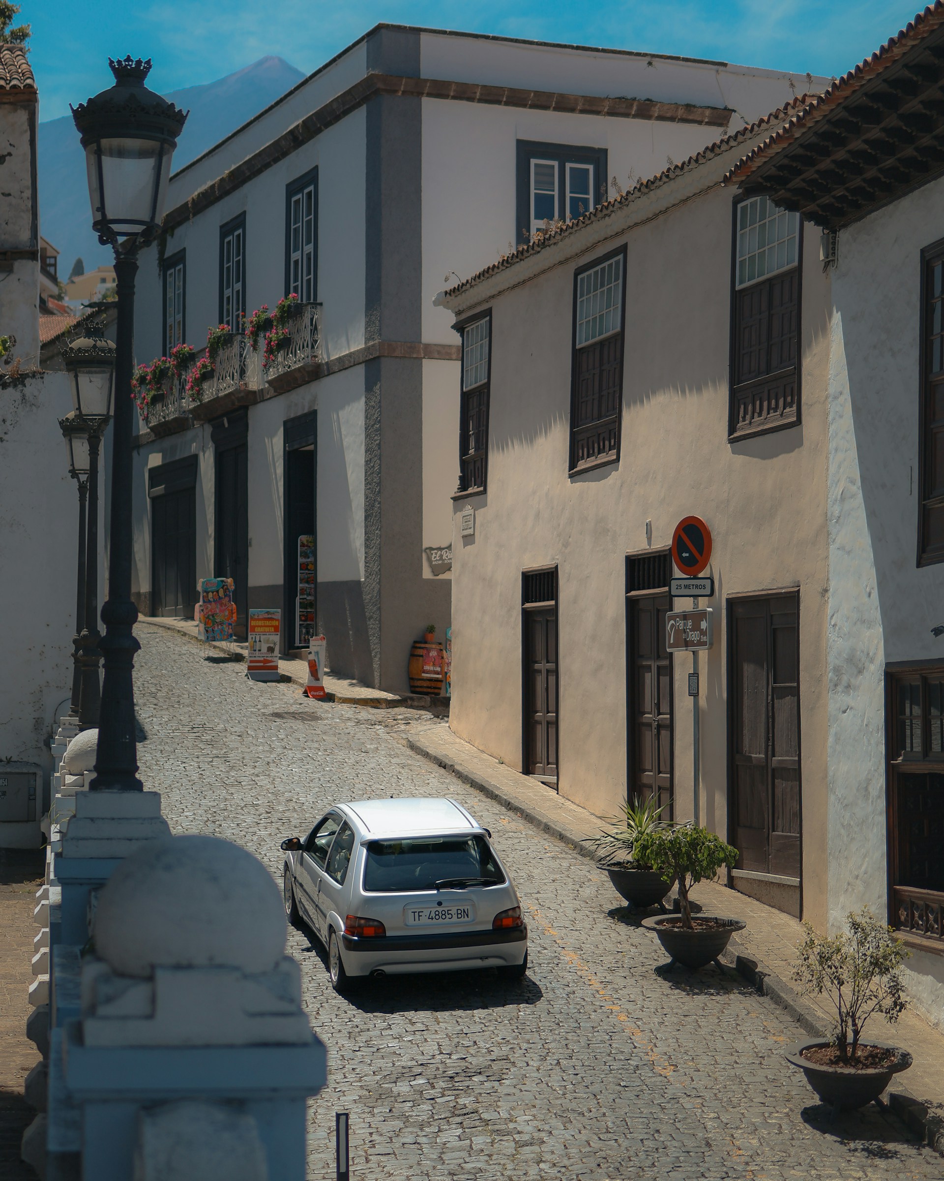 A car is parked on a cobblestone street