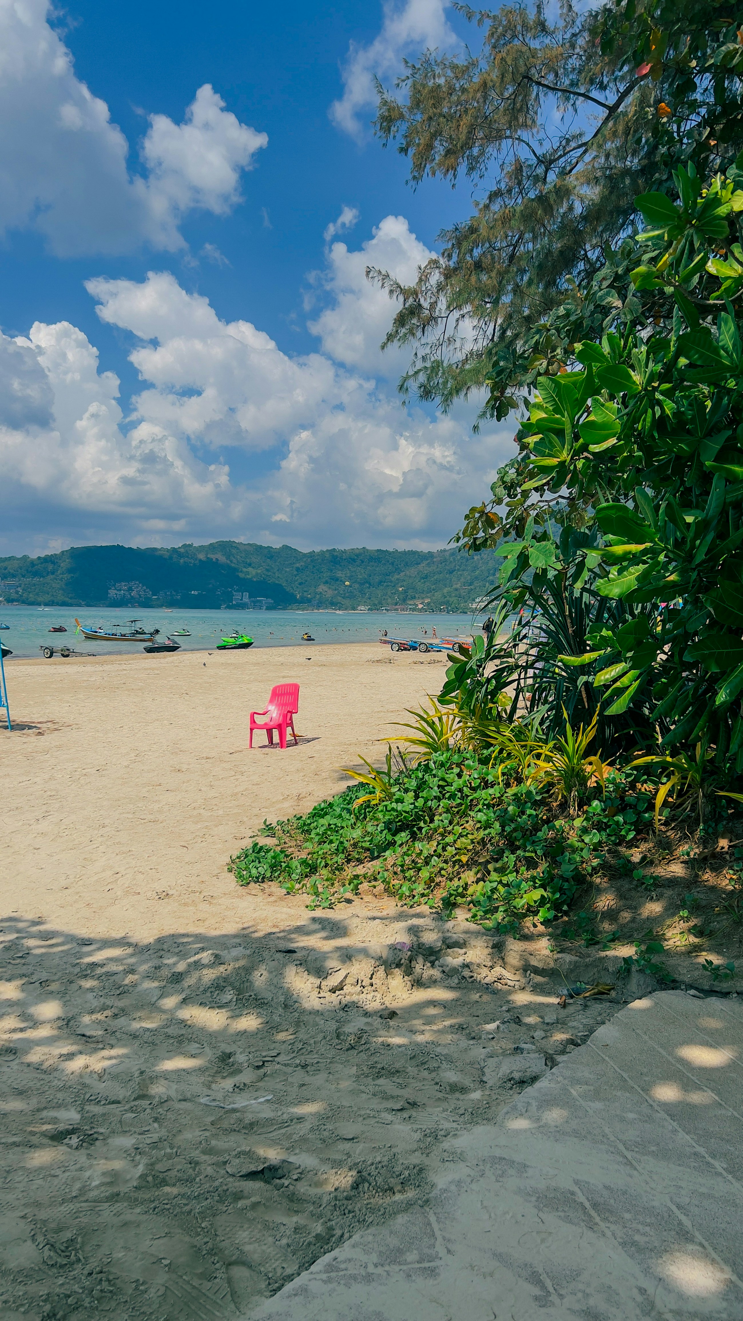 A red chair sitting on top of a sandy beach