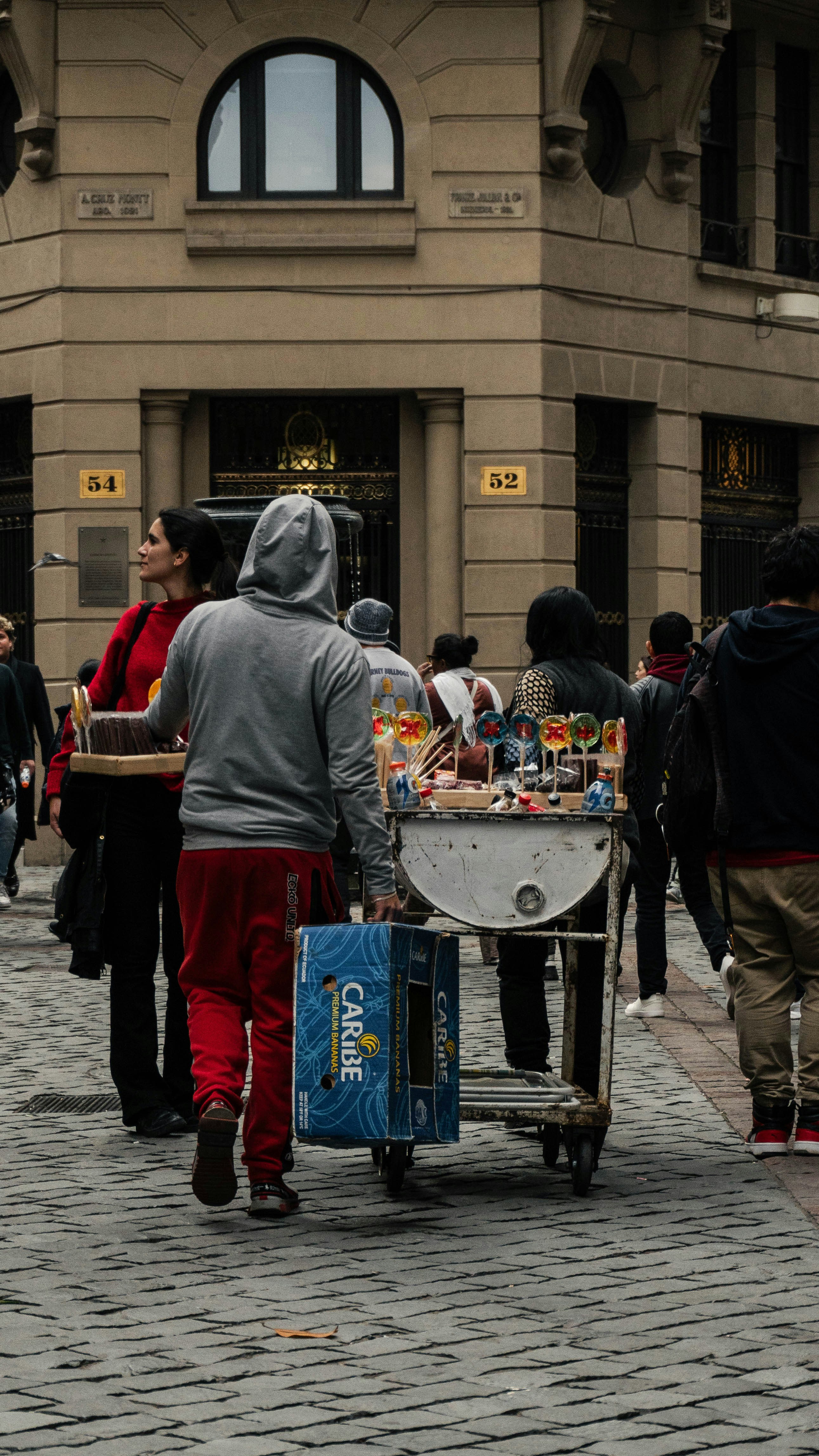 A group of people walking down a street next to a building