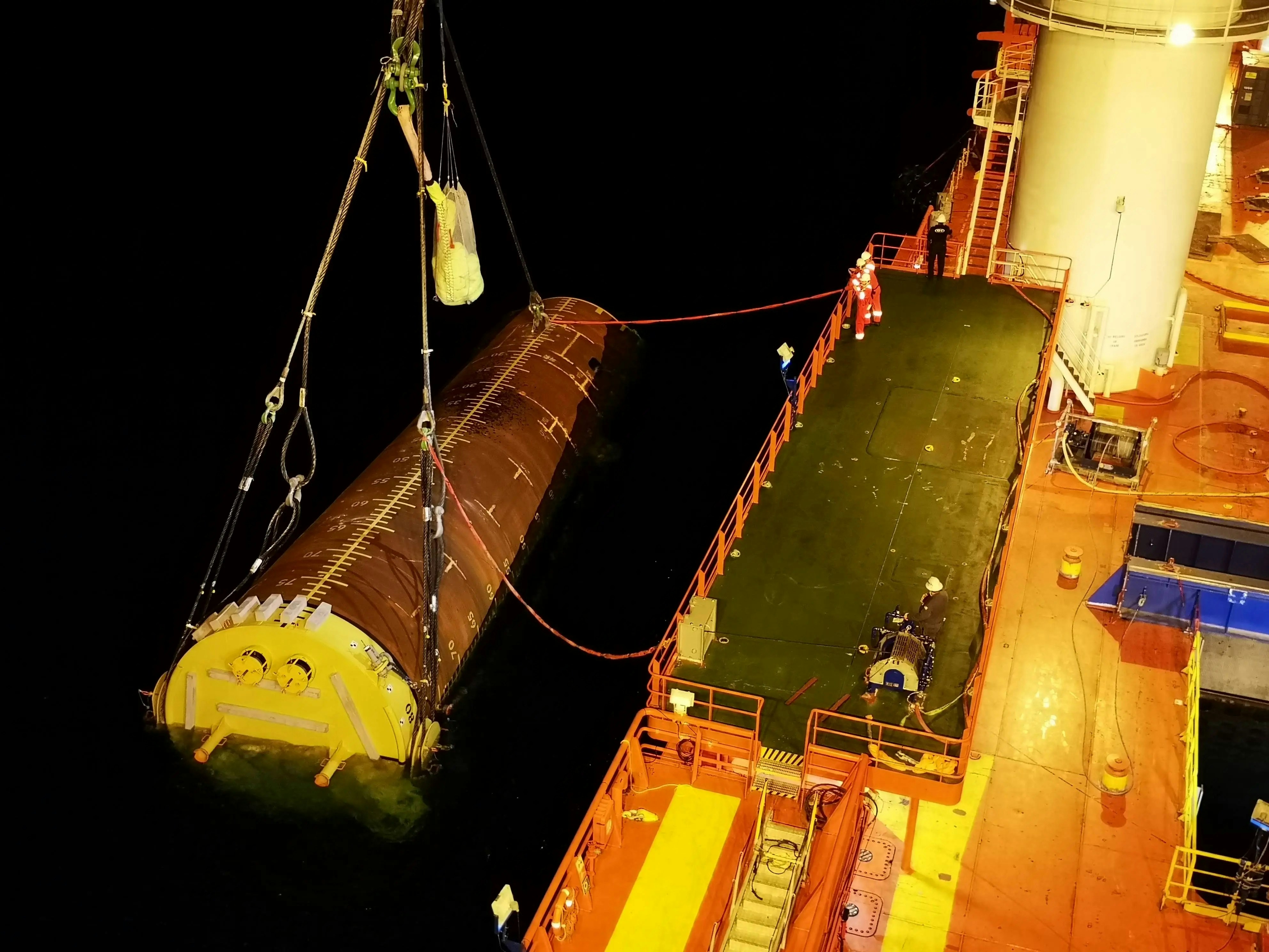 A large boat with a giant yellow object on it's side