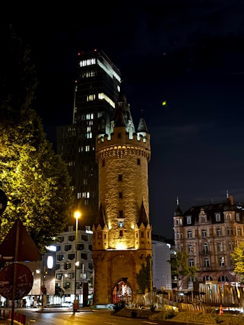 A tall tower sitting next to a street at night