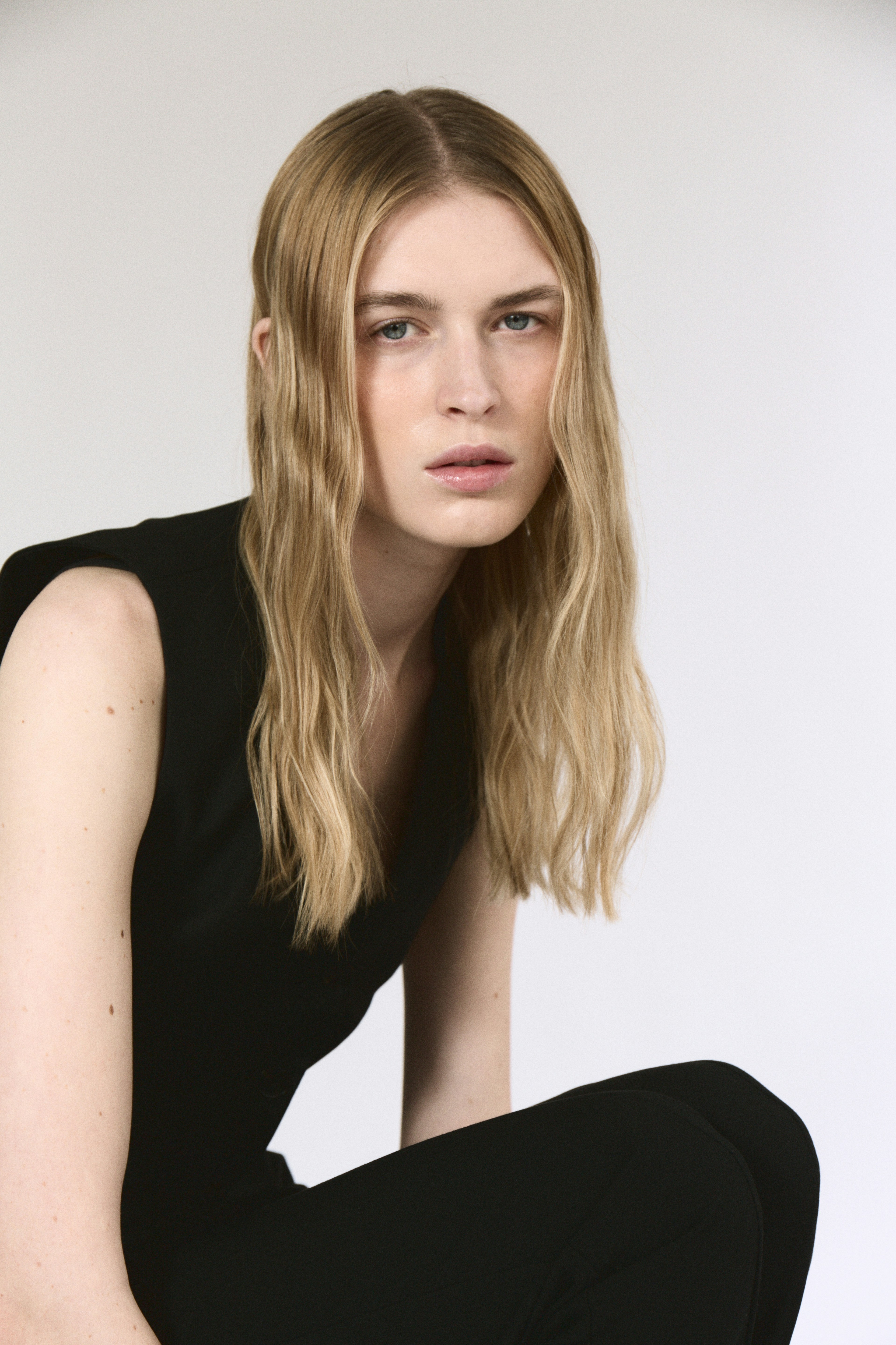 A woman sitting on the ground with her legs crossed