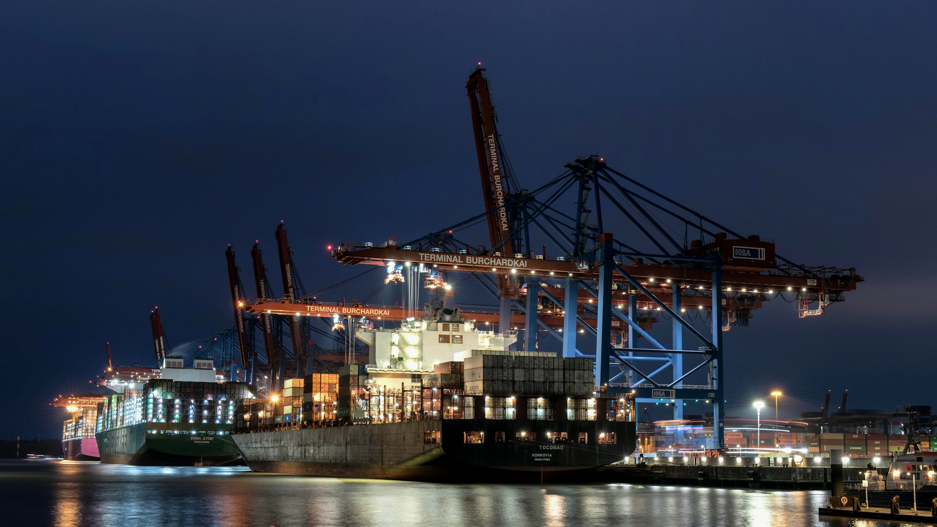 A large cargo ship docked at a dock at night