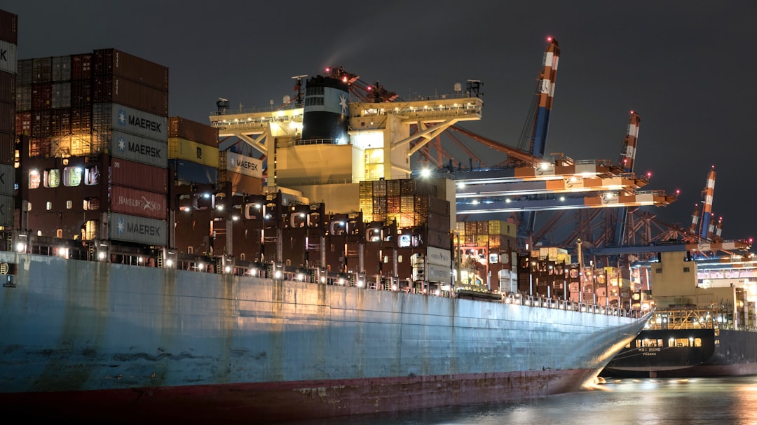 A large cargo ship in a harbor at night,