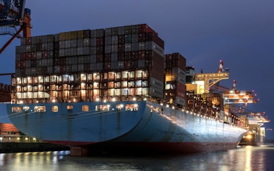 A large cargo ship in a harbor at night