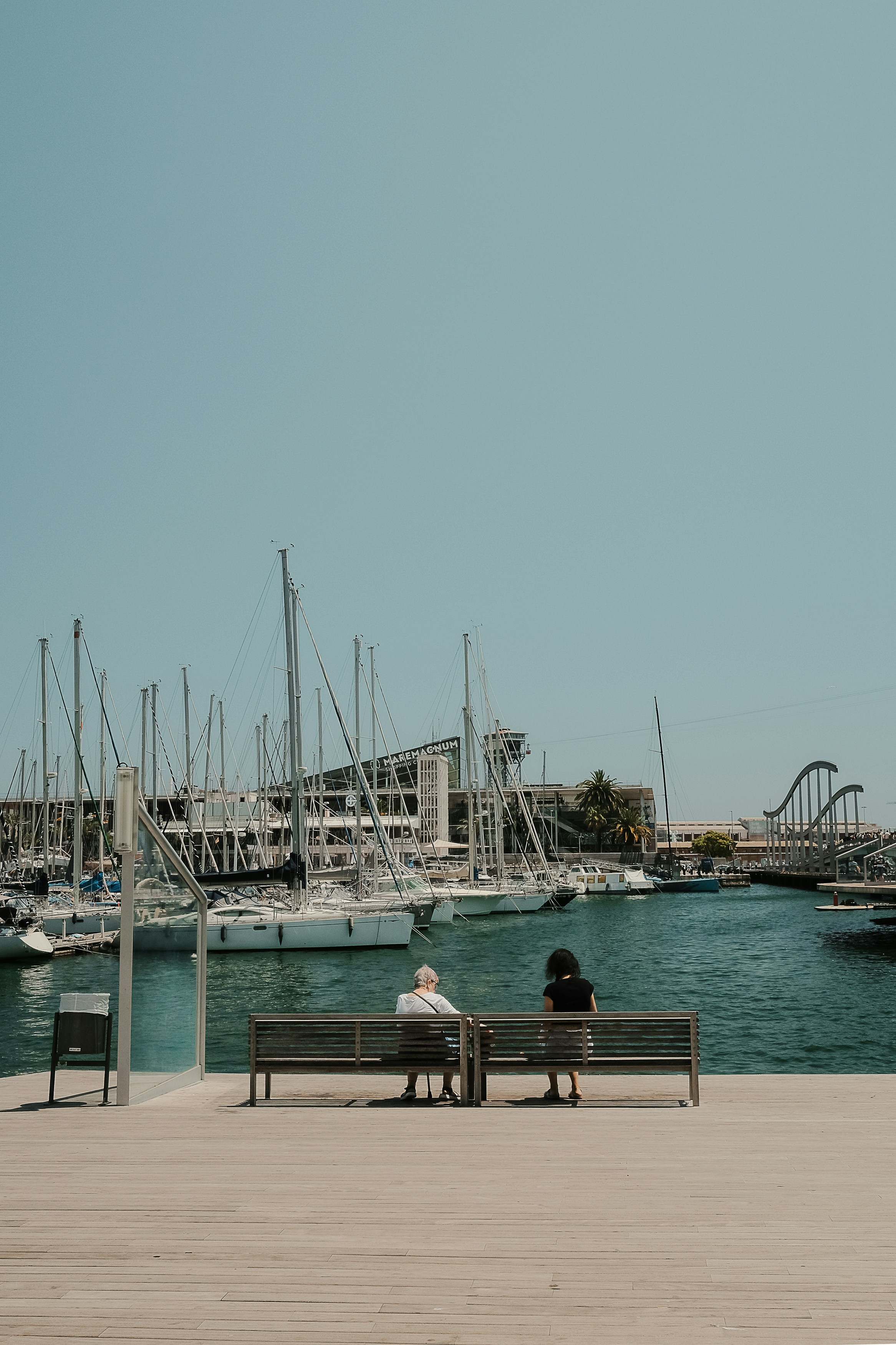 Deux personnes assises sur un banc près d’un port