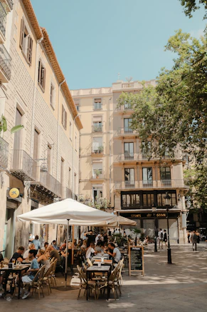 A group of people sitting at tables under umbrellas