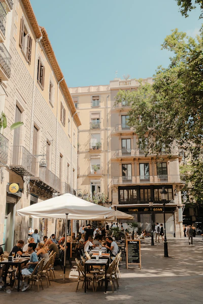 A group of people sitting at tables under umbrellas