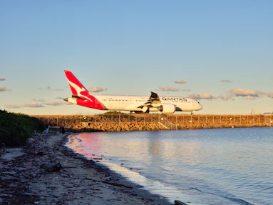 A large jetliner flying over a body of water