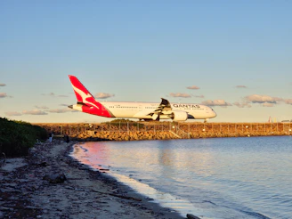 A large jetliner flying over a body of water
