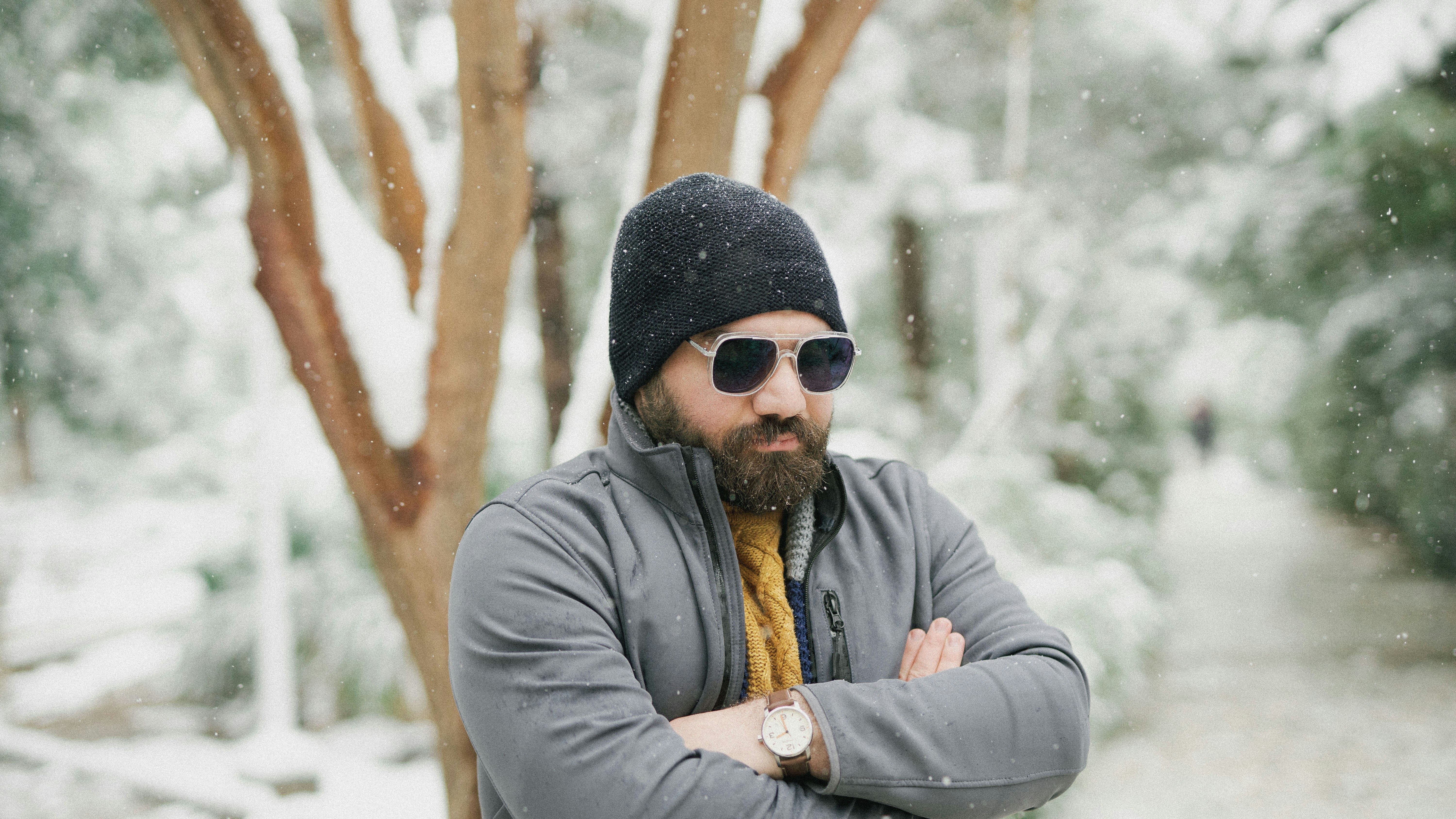 A man with his arms crossed standing in the snow