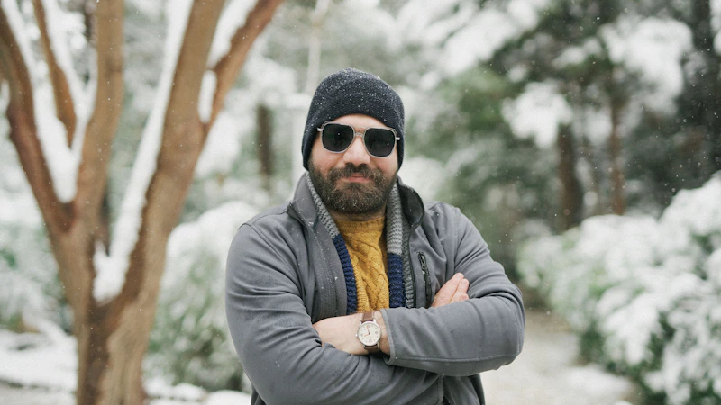 Un sugar baby con sombrero y gafas de sol de pie en la nieve.