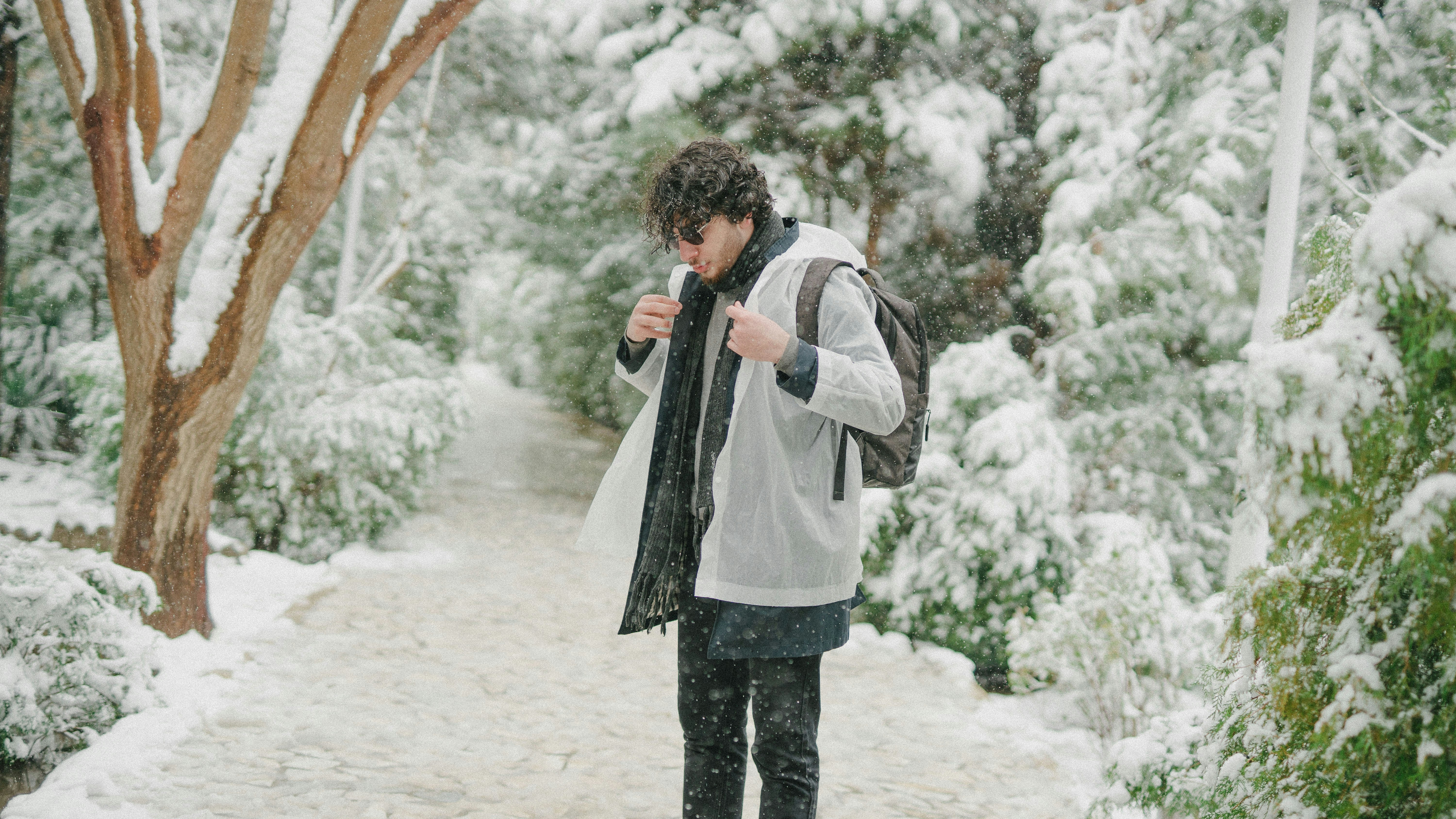 A young man standing on a snow covered path