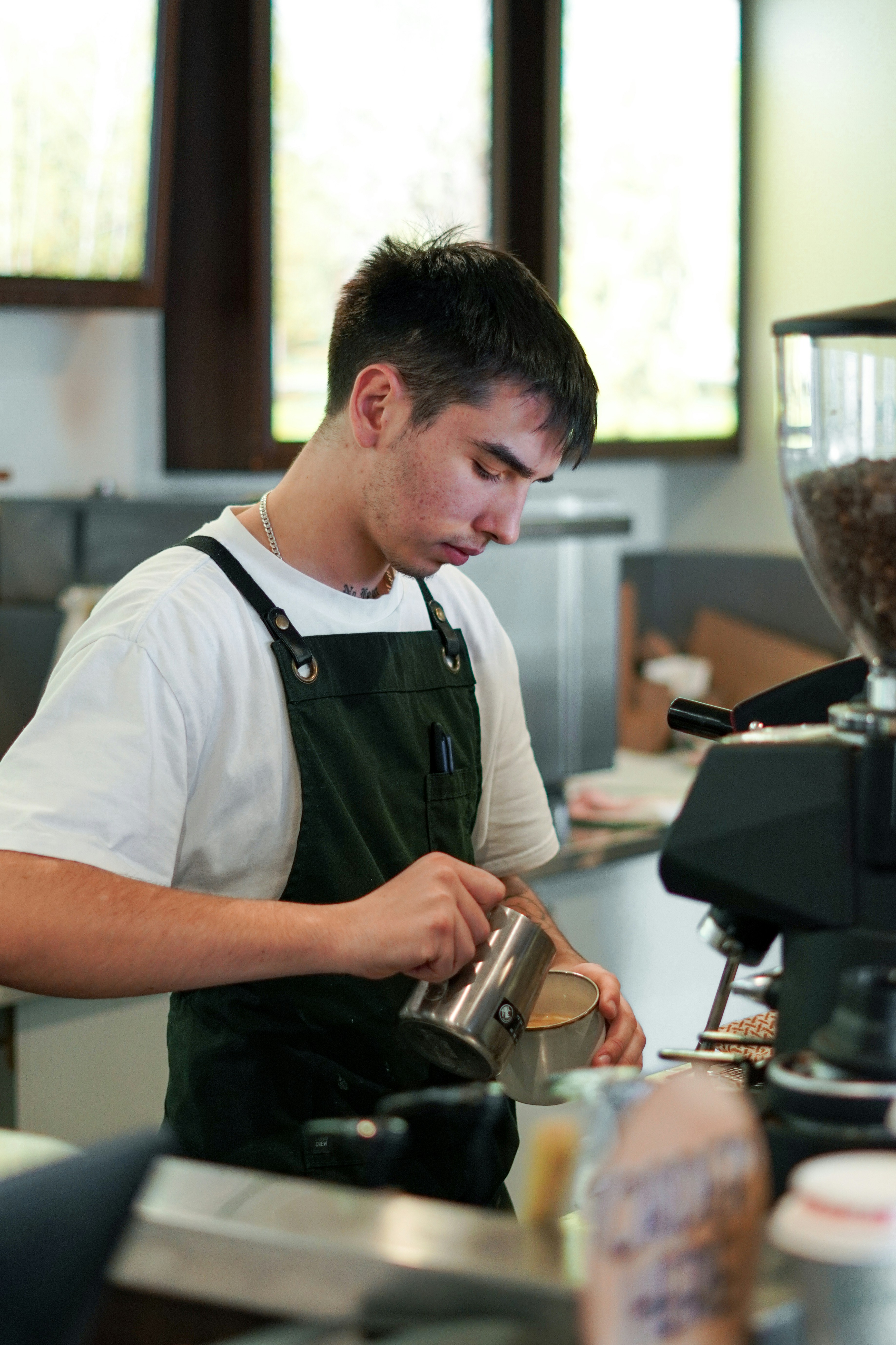 A man pouring a cup of coffee in a coffee shop