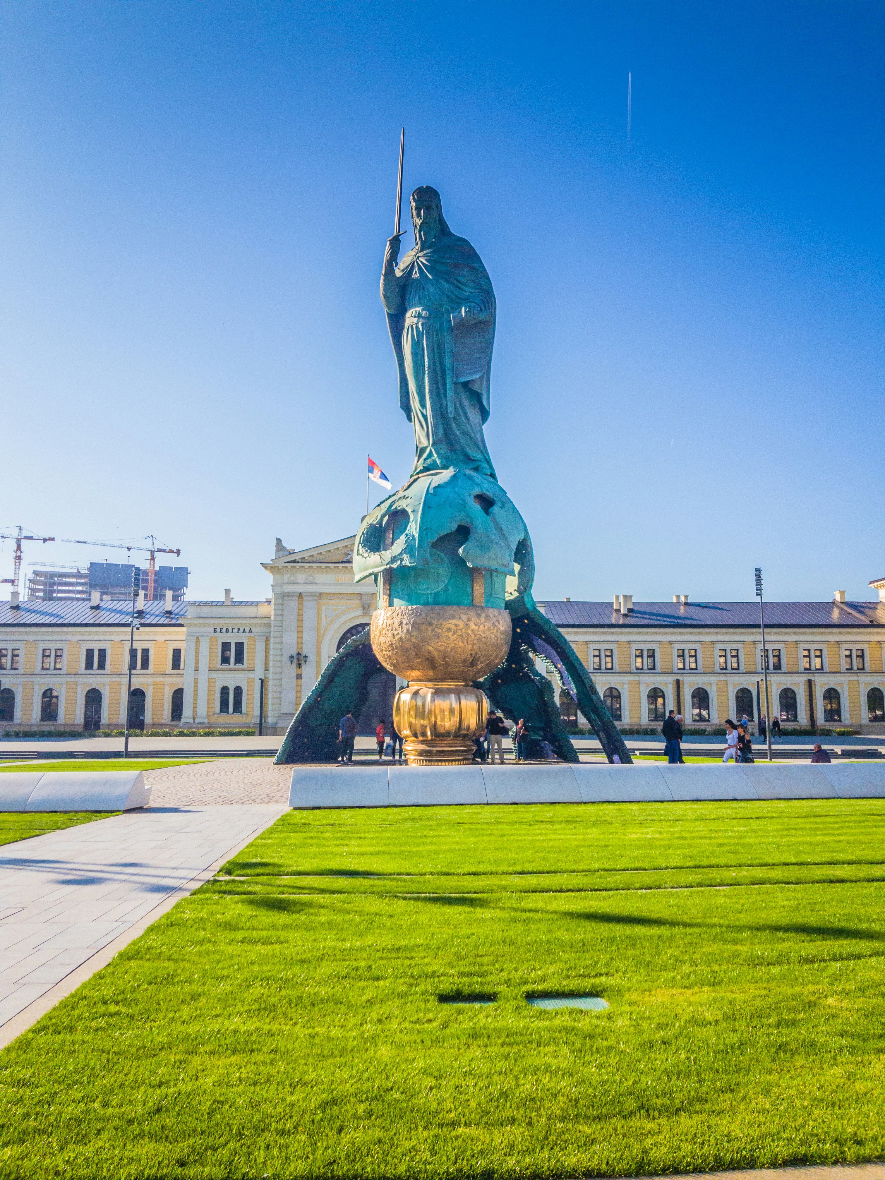 Uma estátua de um homem segurando uma espada na frente de um edifício