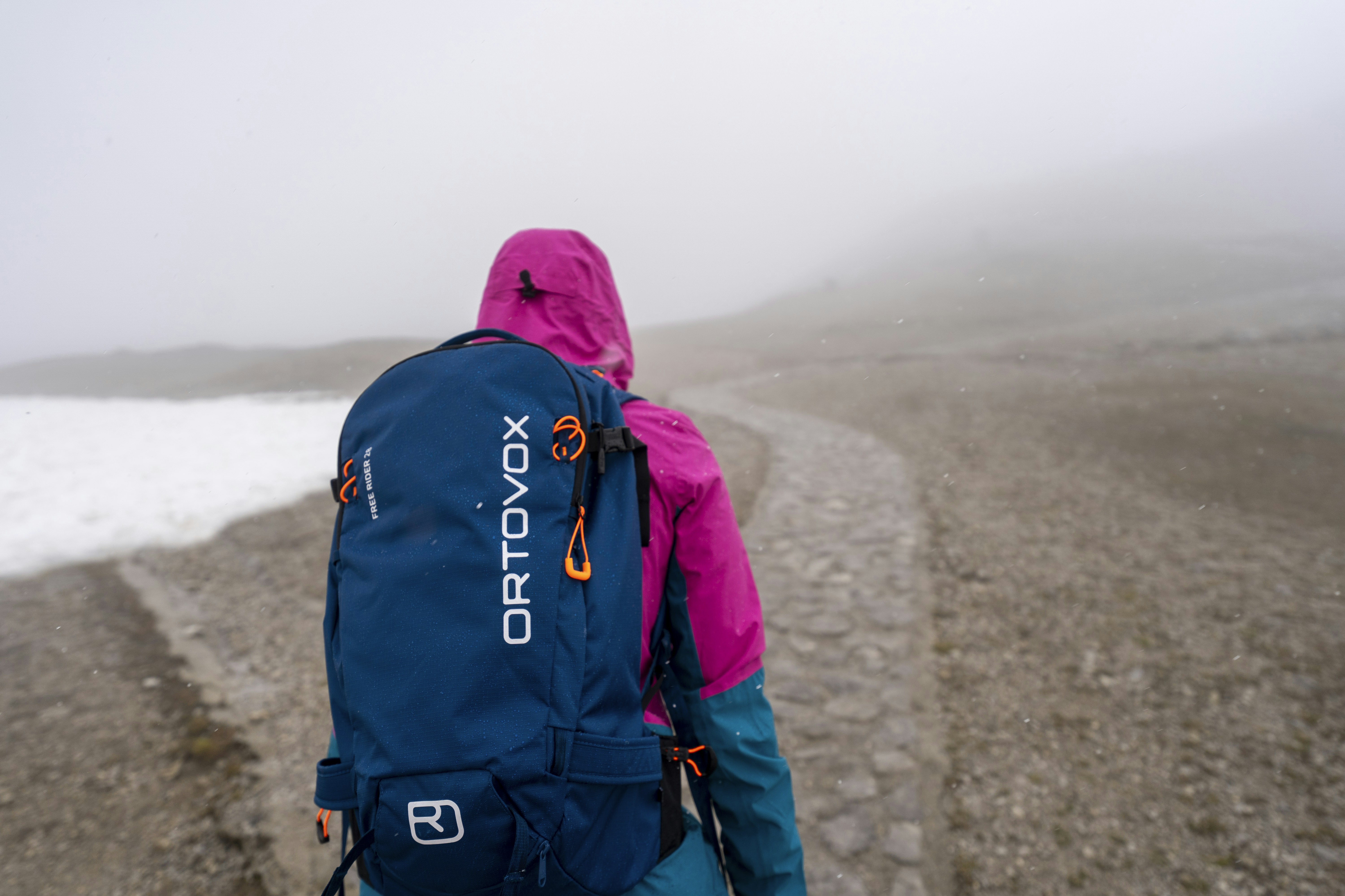 A person with a back pack walking on a foggy road