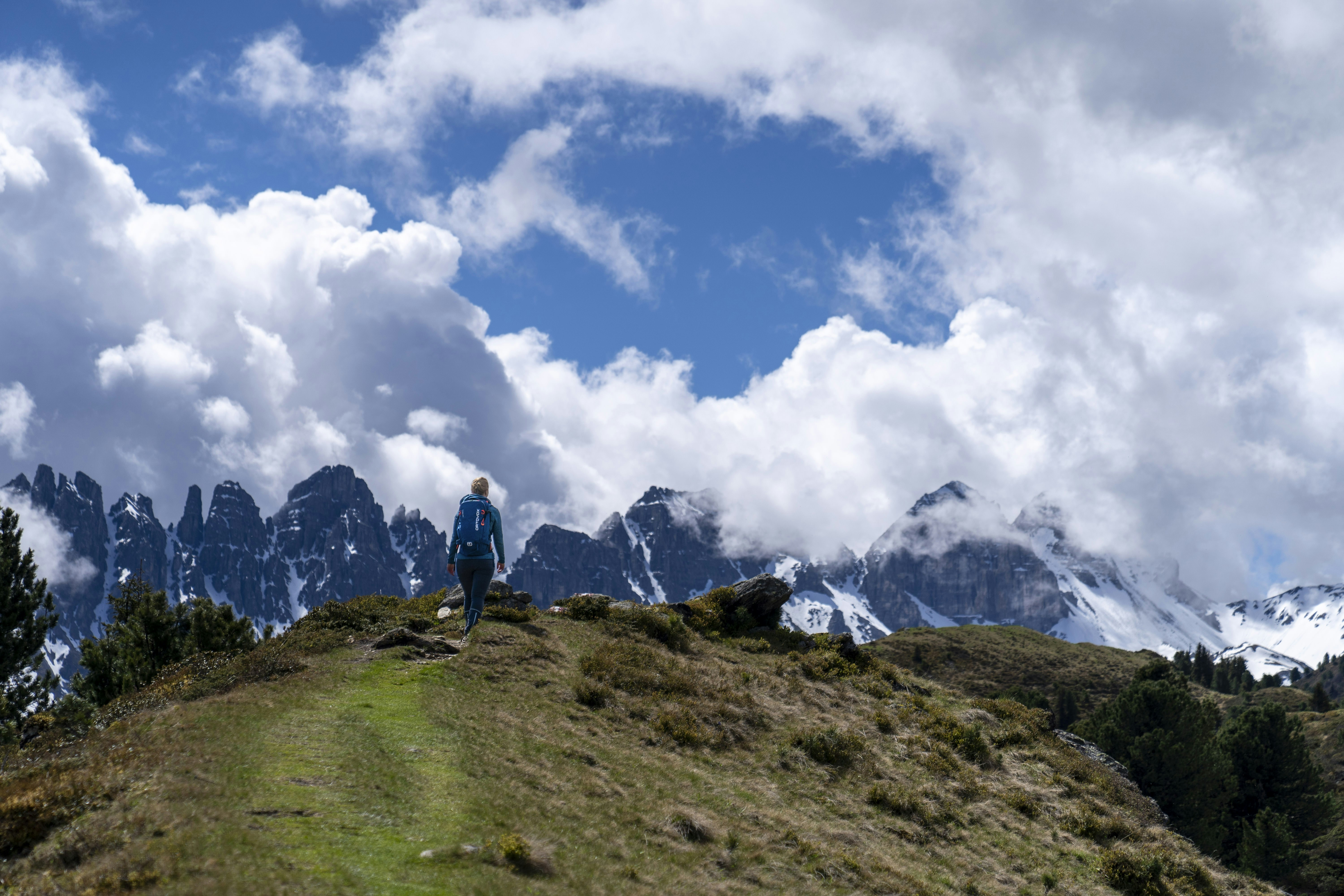 A man standing on top of a lush green hillside