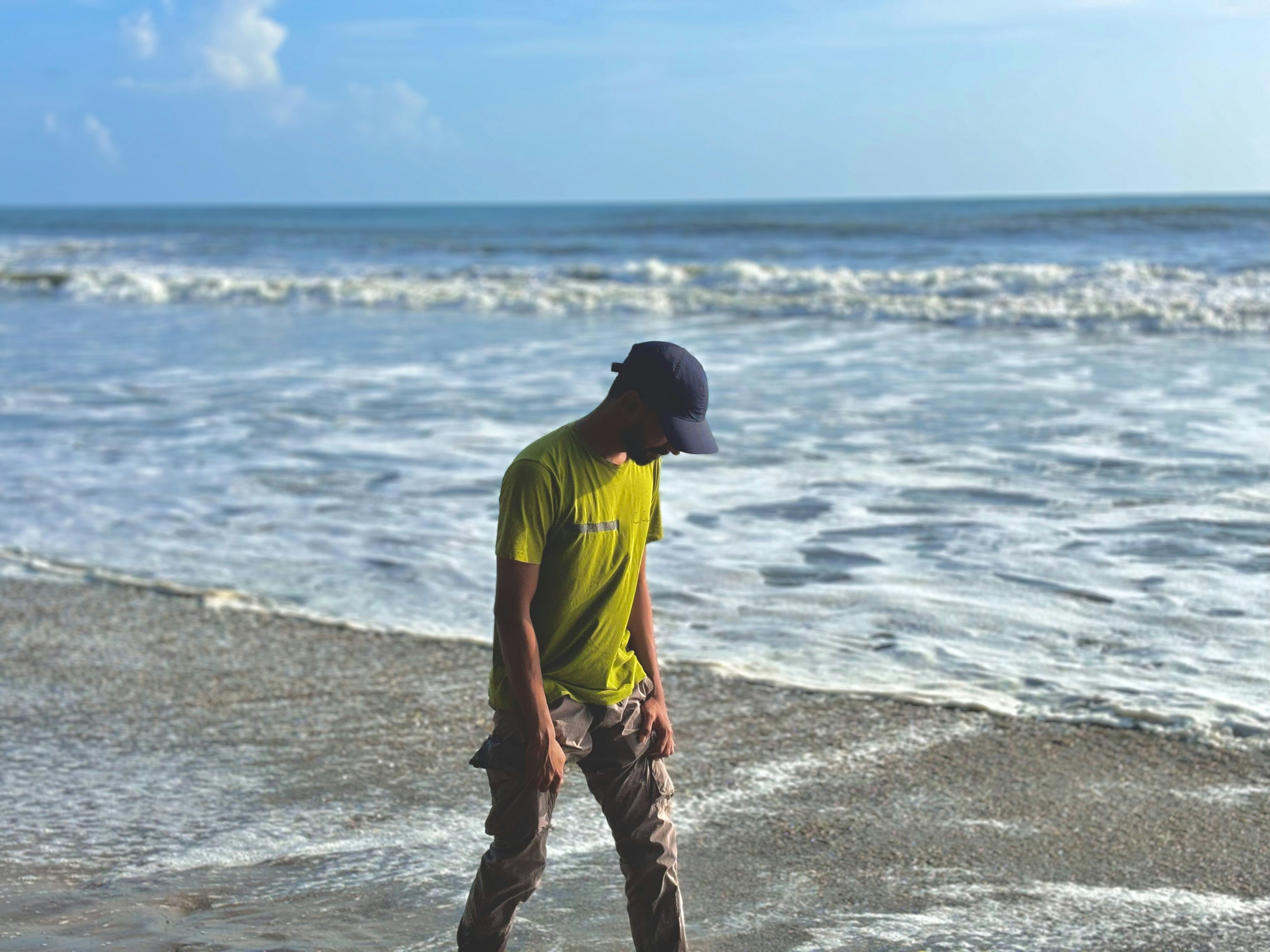 A man standing on a beach next to the ocean