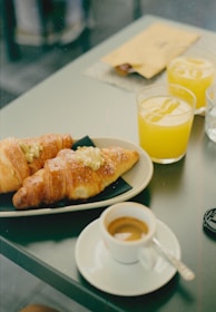 A table topped with a plate of food next to a cup of coffee