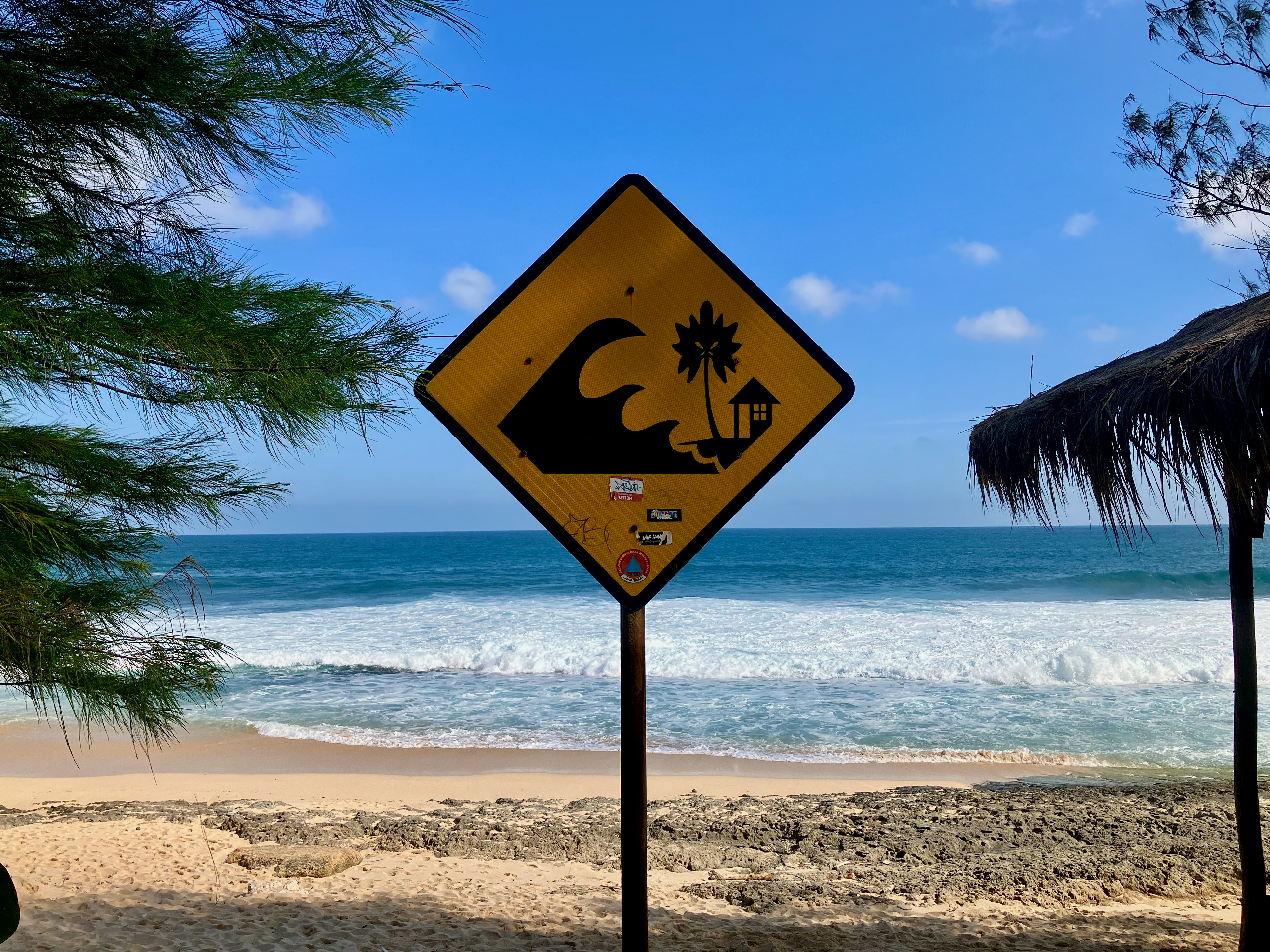 A yellow sign sitting on the side of a beach