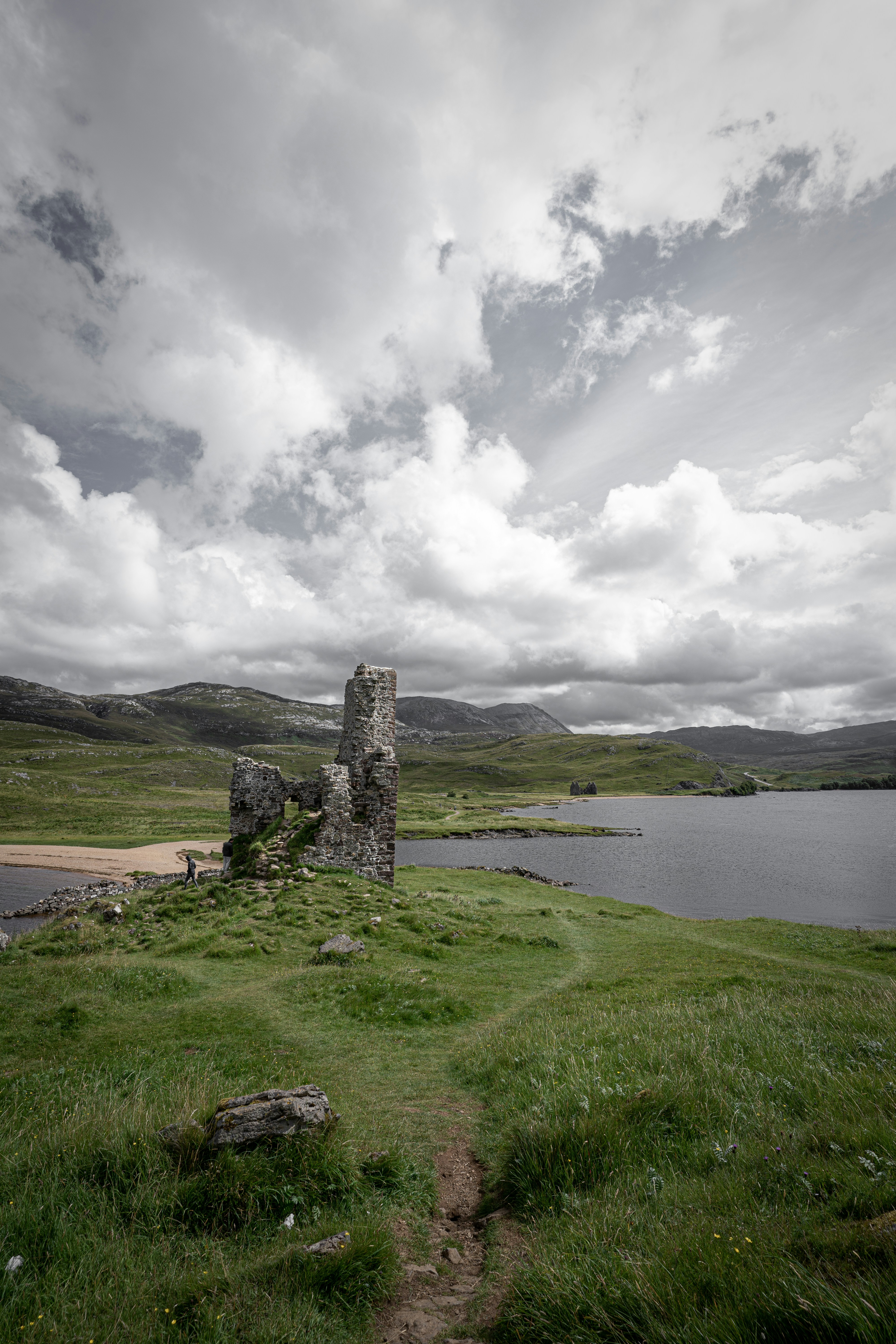 A large body of water sitting next to a lush green field