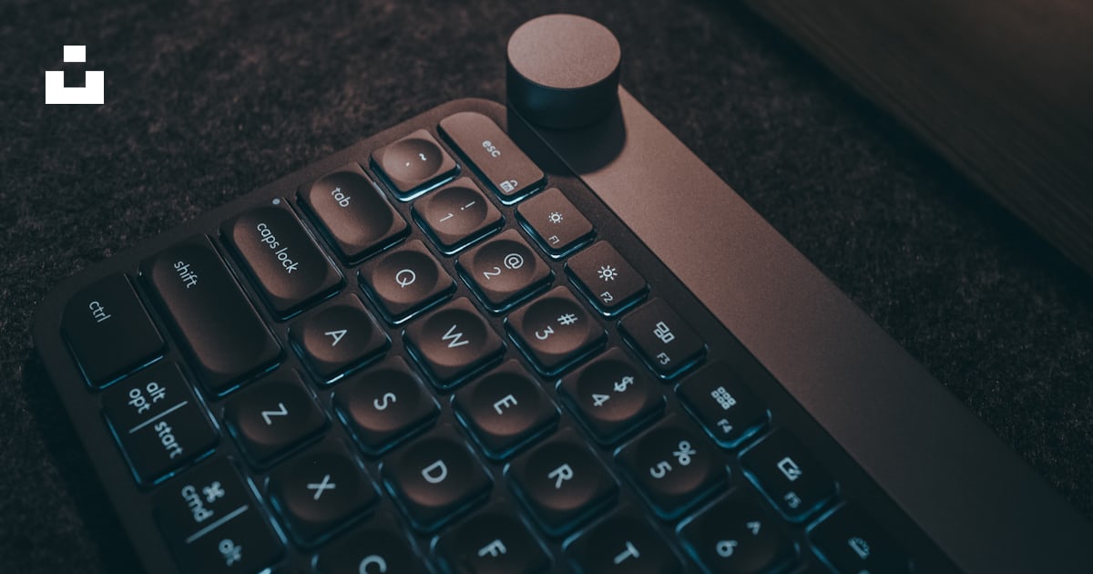 A computer keyboard sitting on the floor next to a couch photo – Free ...