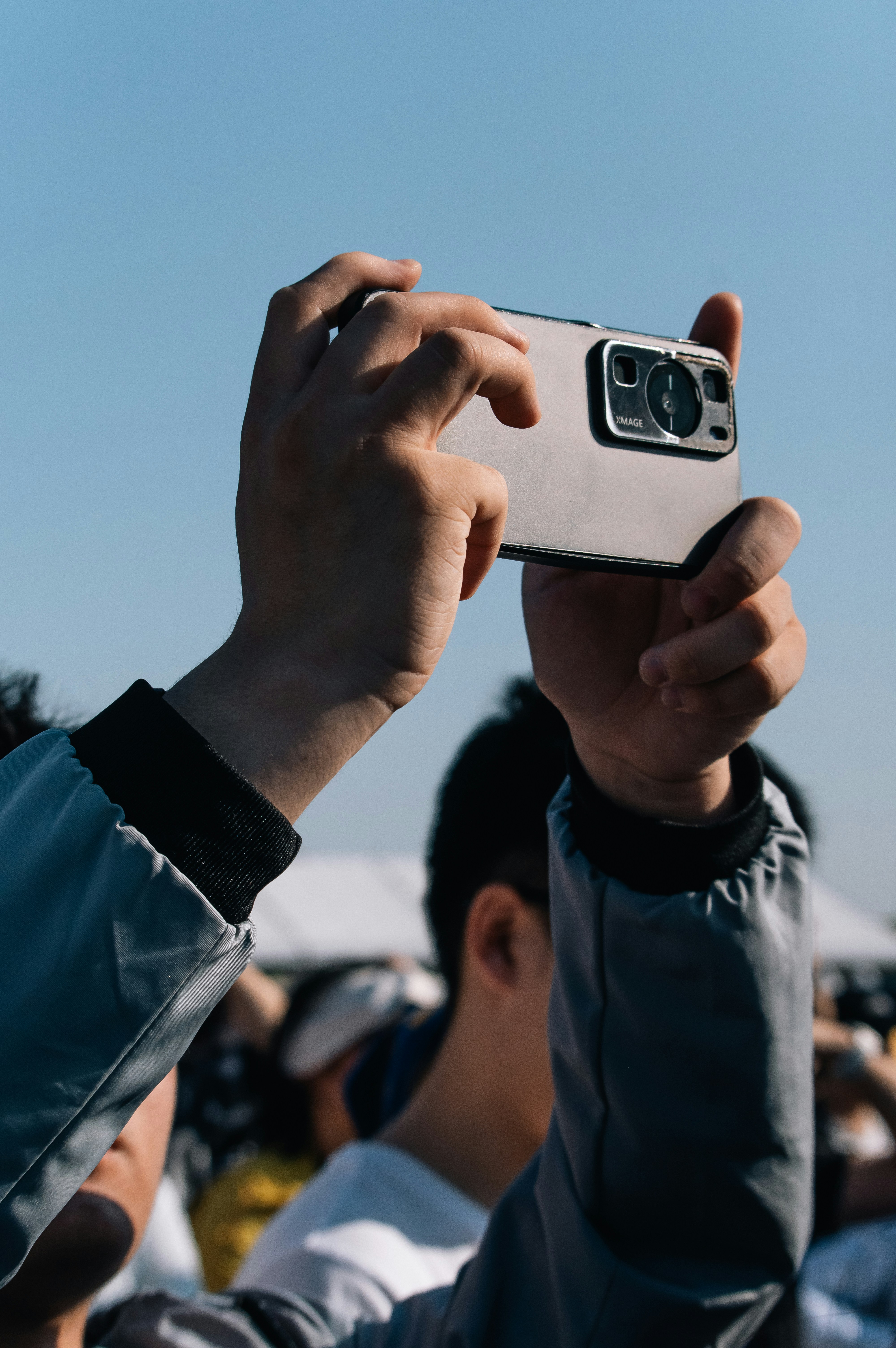 A person extending their arm forward holding a phone.