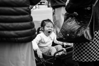 A little girl sitting in the back of a small cart
