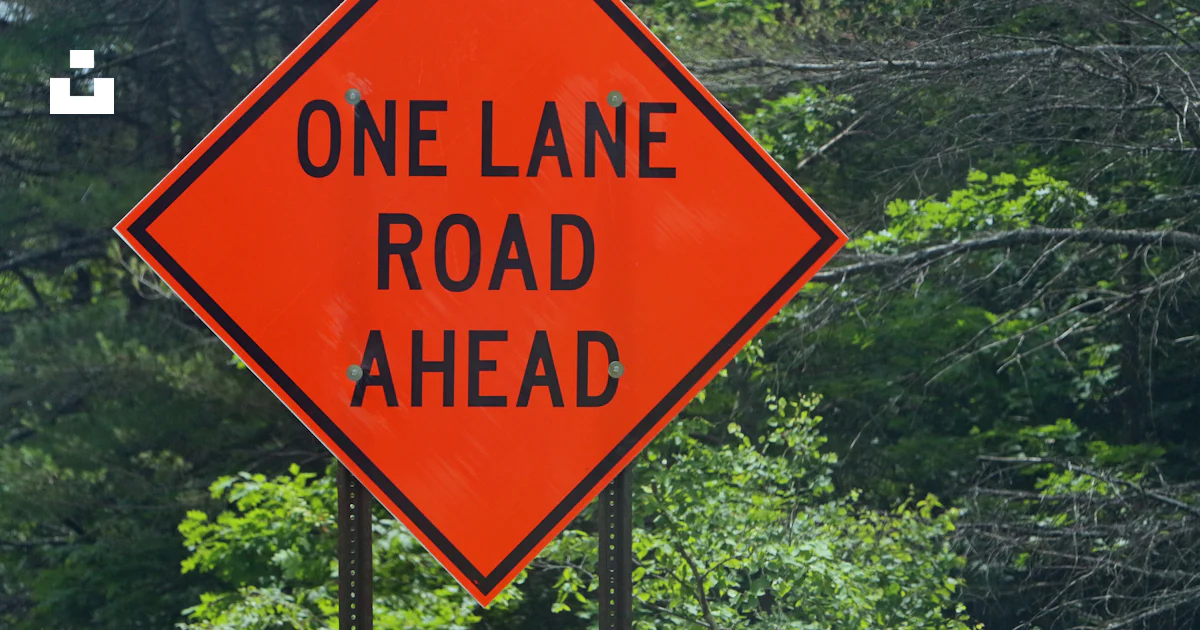 One Lane Rd A one lane road ahead sign in front of trees photo – Free Quechee Image ...