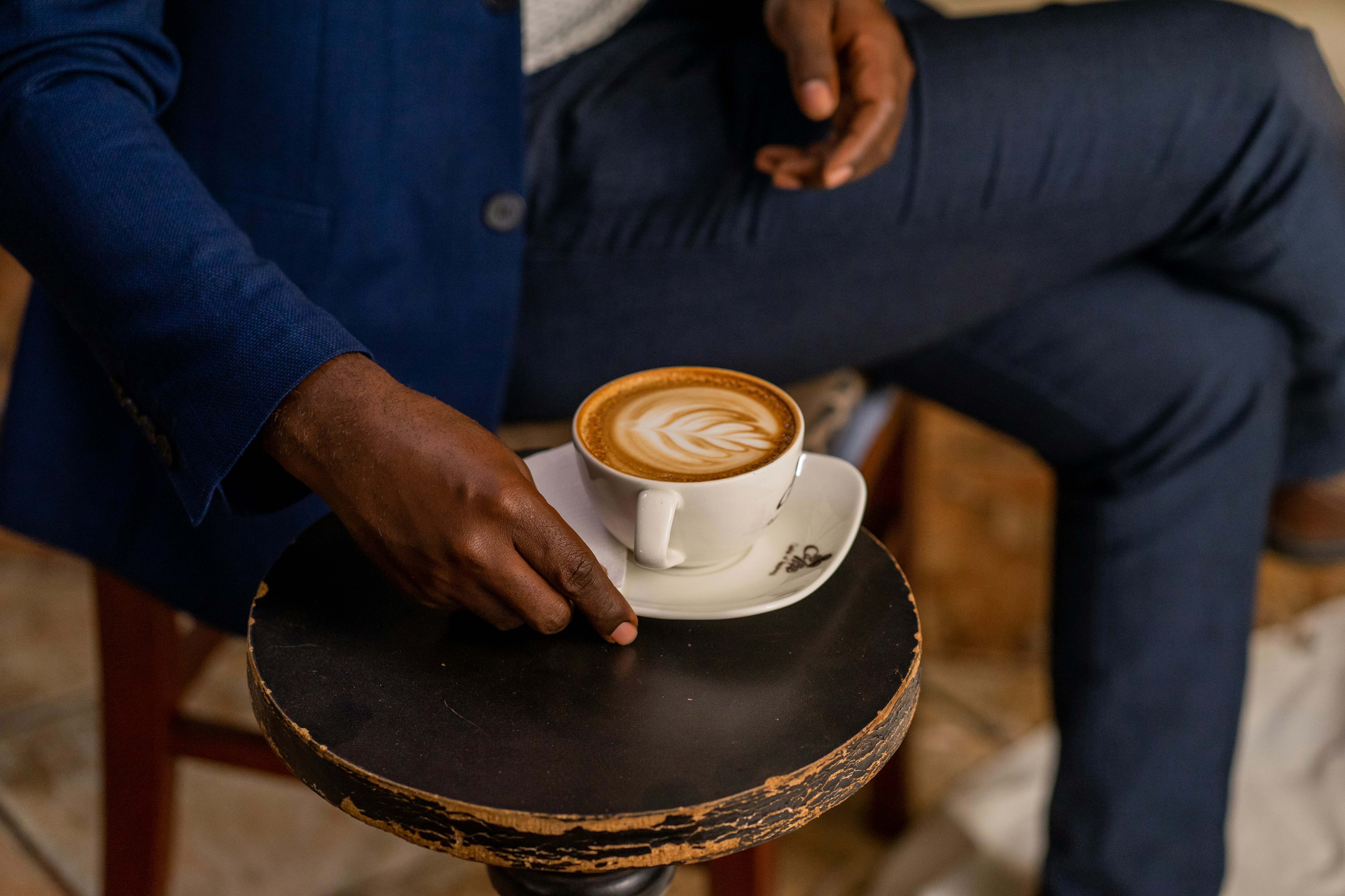A man sitting in a chair holding a cup of coffee