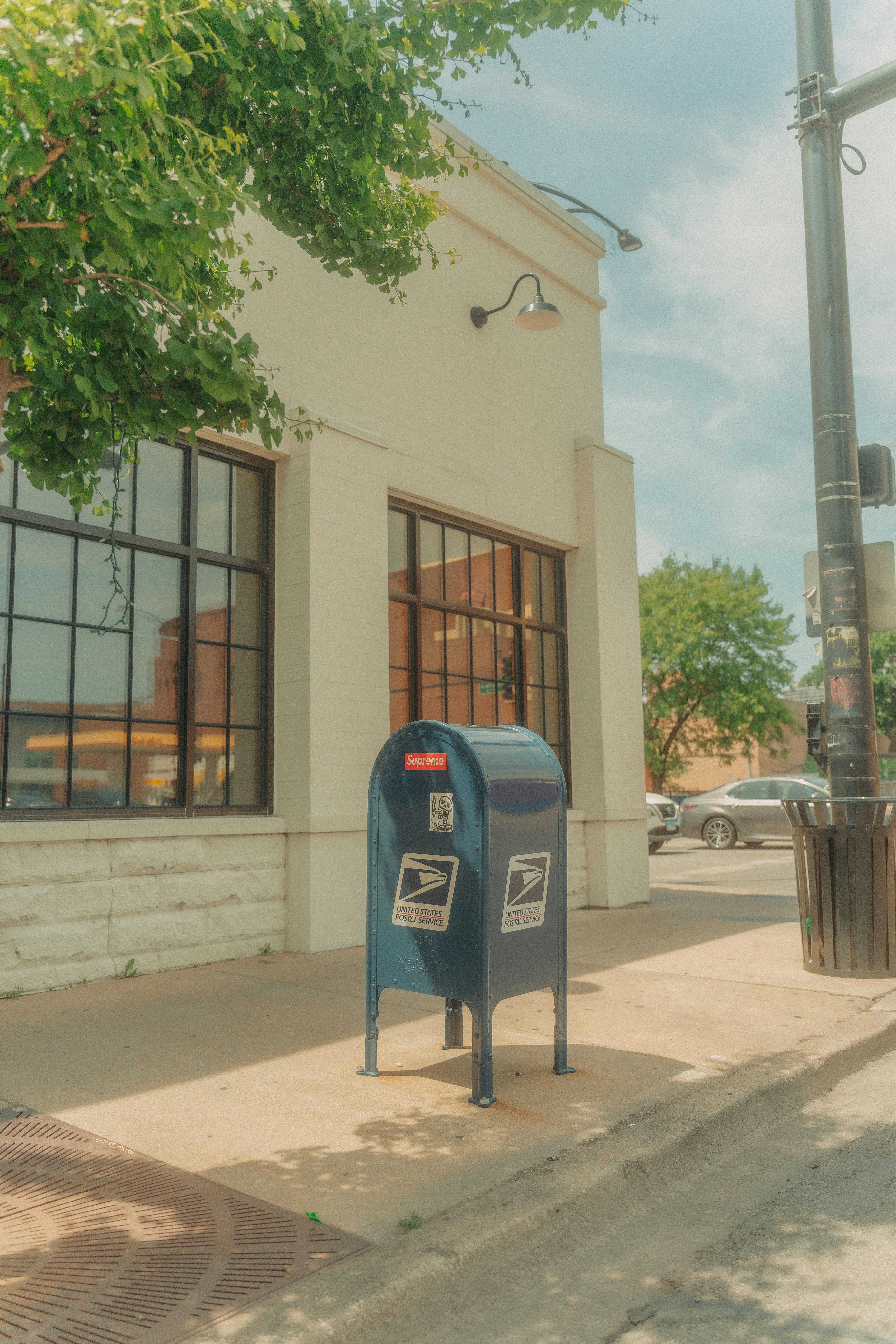A blue mailbox sitting on the side of a street