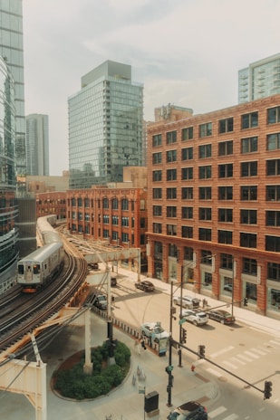 A train traveling through a city next to tall buildings