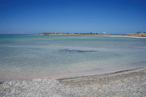 A body of water sitting next to a sandy beach
