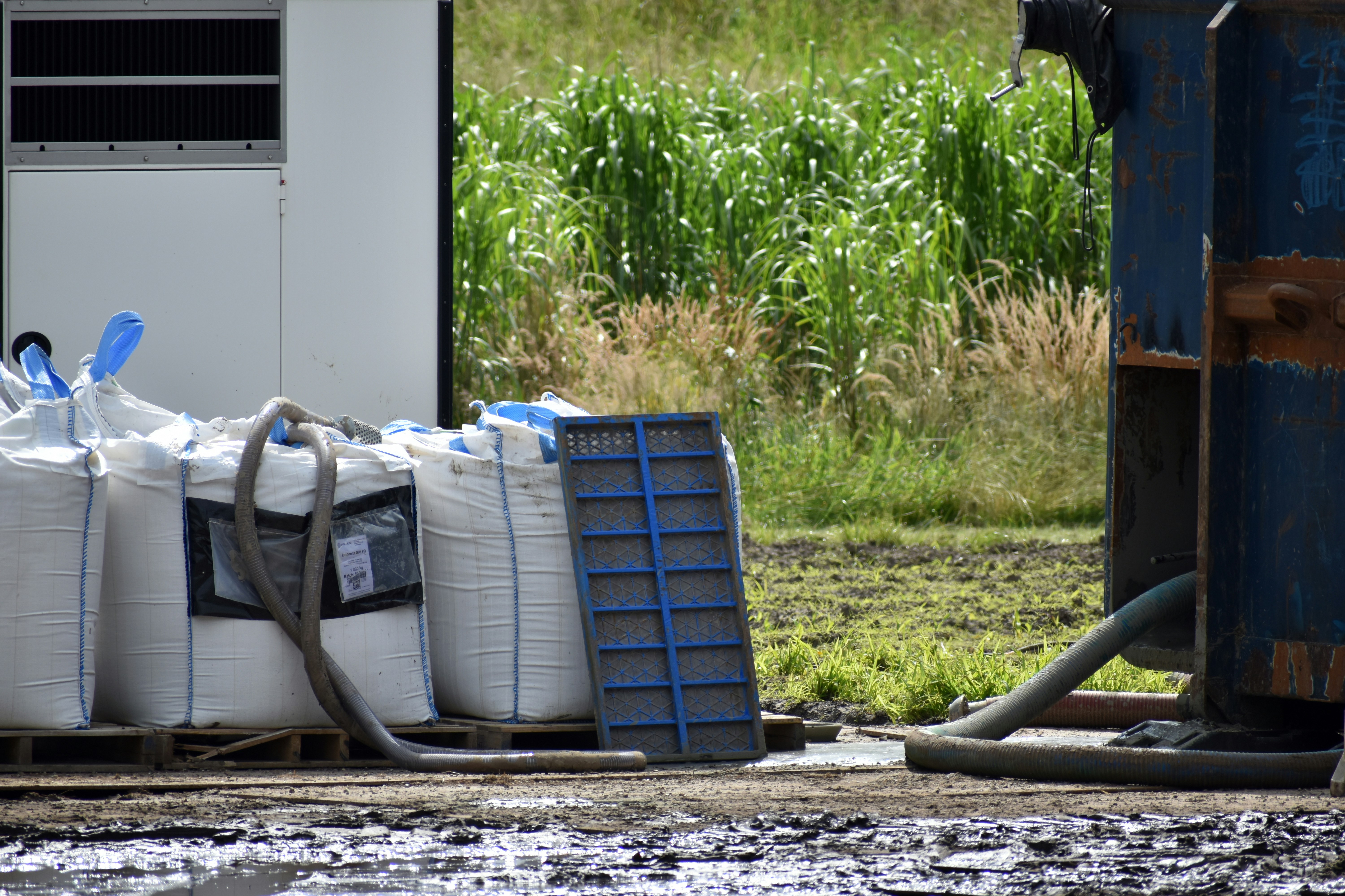 A pile of bags sitting next to a trash can
