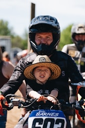 A man riding a motorcycle with a small child on the back of it