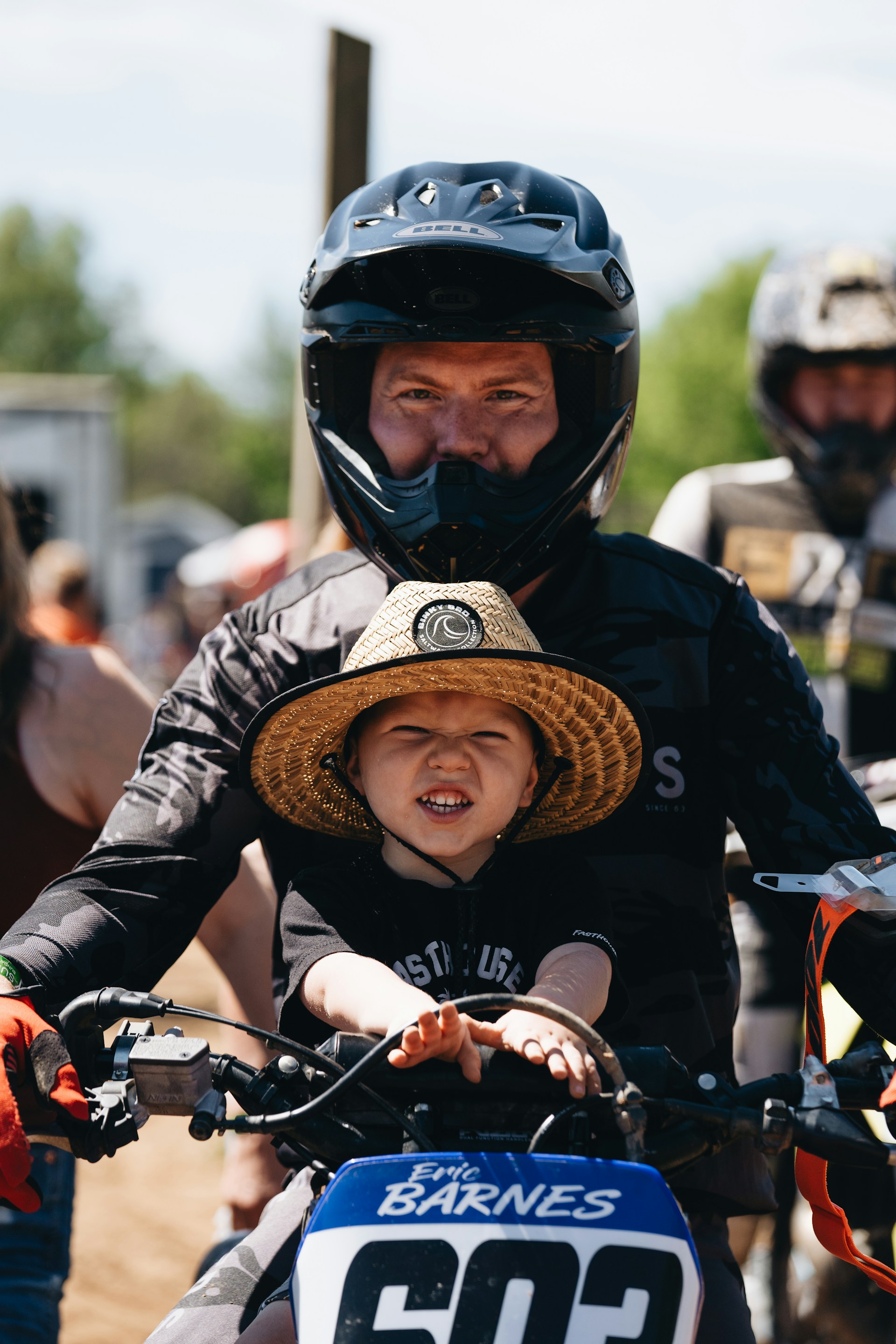 A man riding a motorcycle with a small child on the back of it