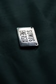 A close up of a metal tag on a black surface