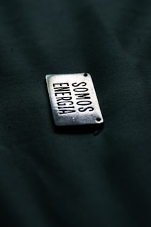 A close up of a metal tag on a black surface