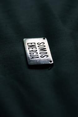 A close up of a metal tag on a black surface