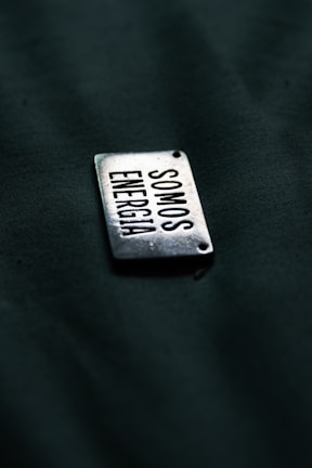 A close up of a metal tag on a black surface