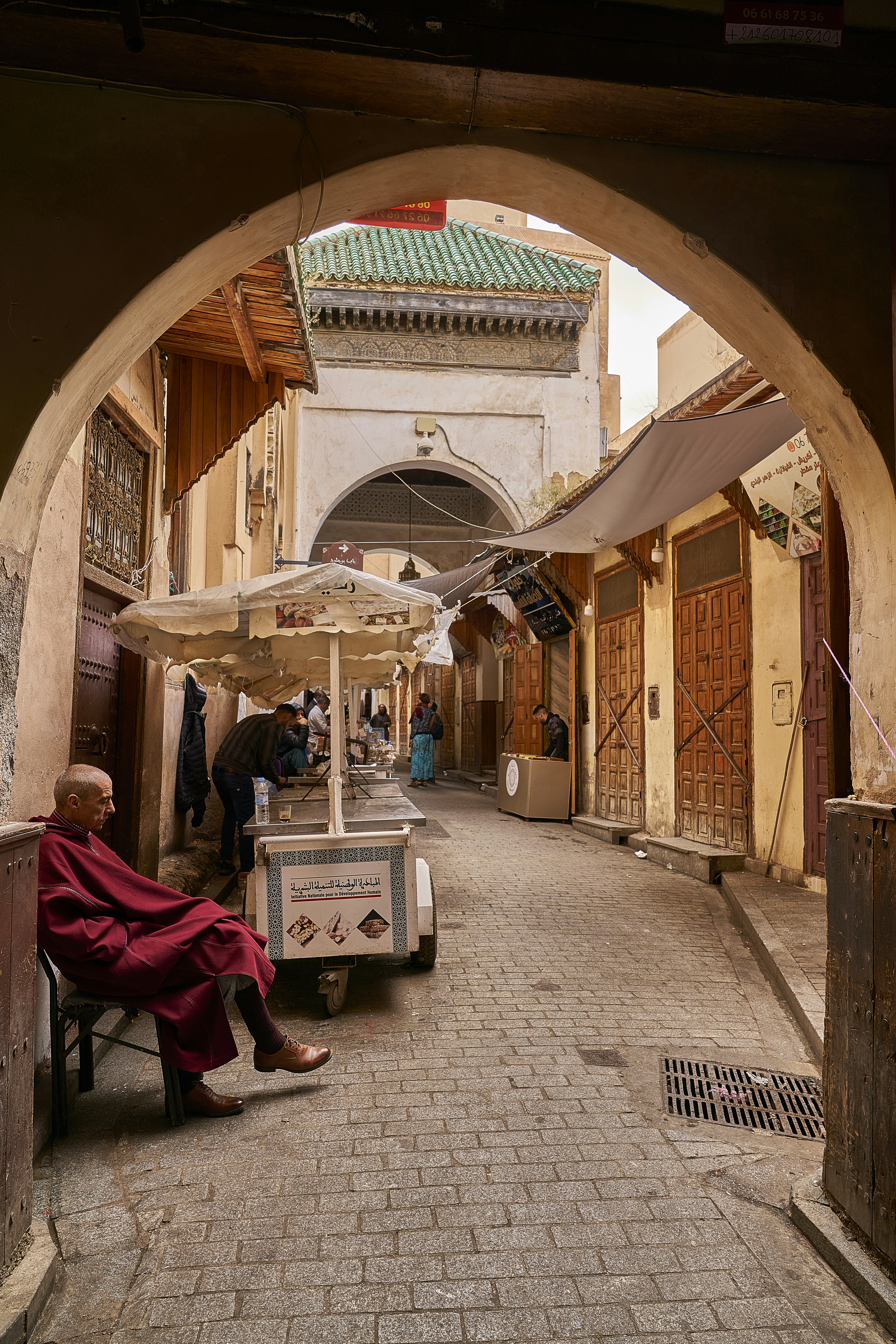 A man sitting on a bench under an archway