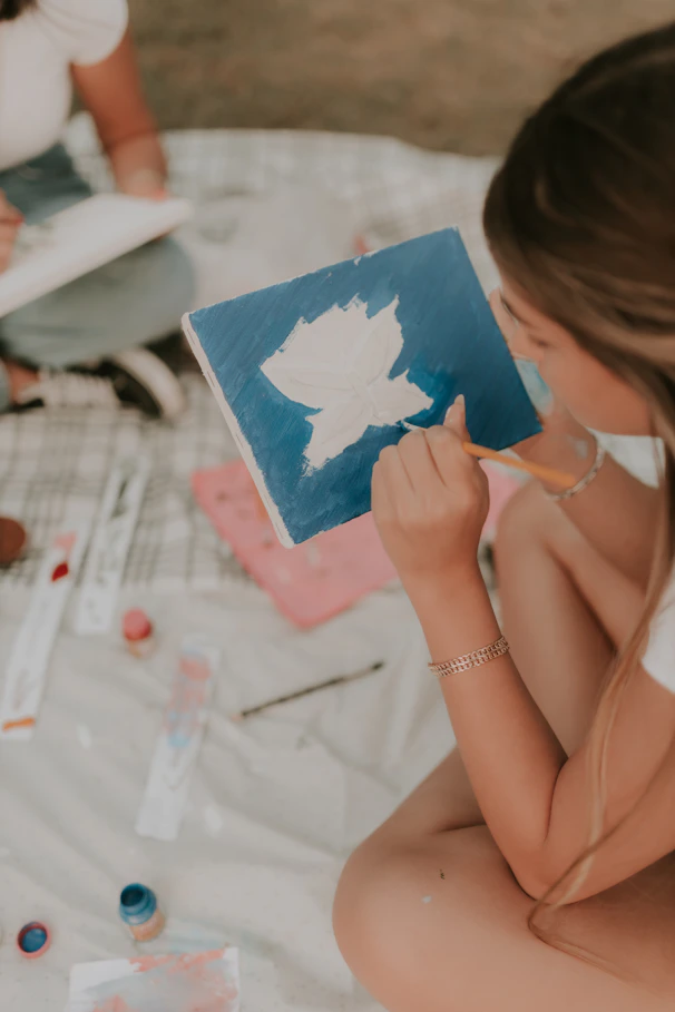 A woman sitting on a bed holding a book