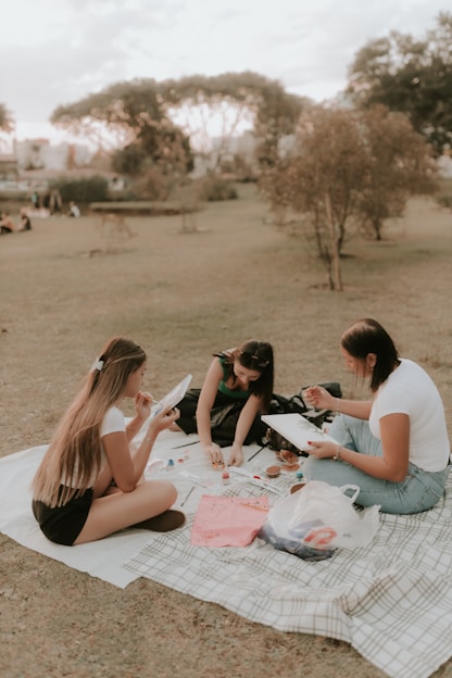A group of people sitting on top of a blanket