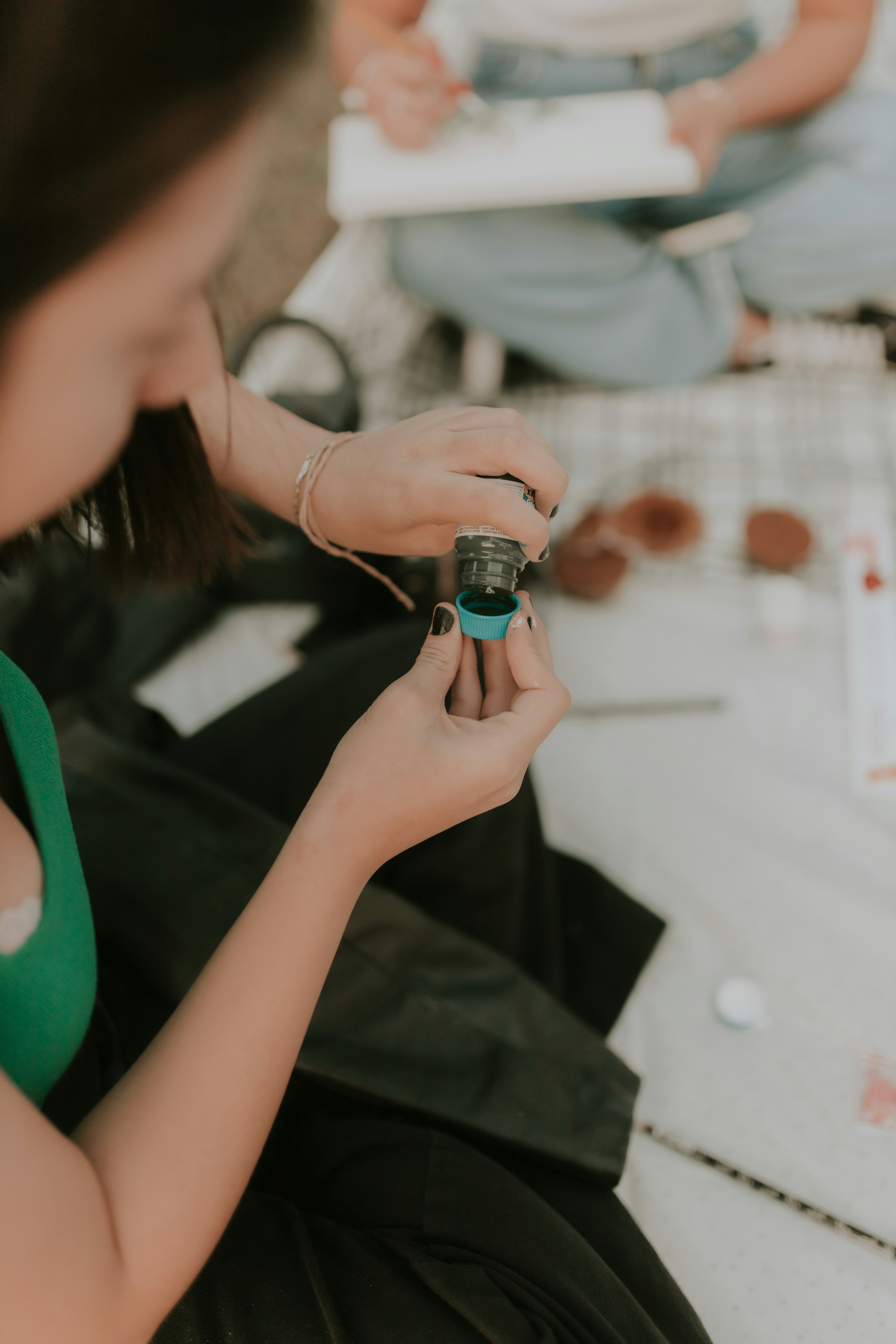 Beginner practicing dotting tools for nail art on freshly painted nails at home