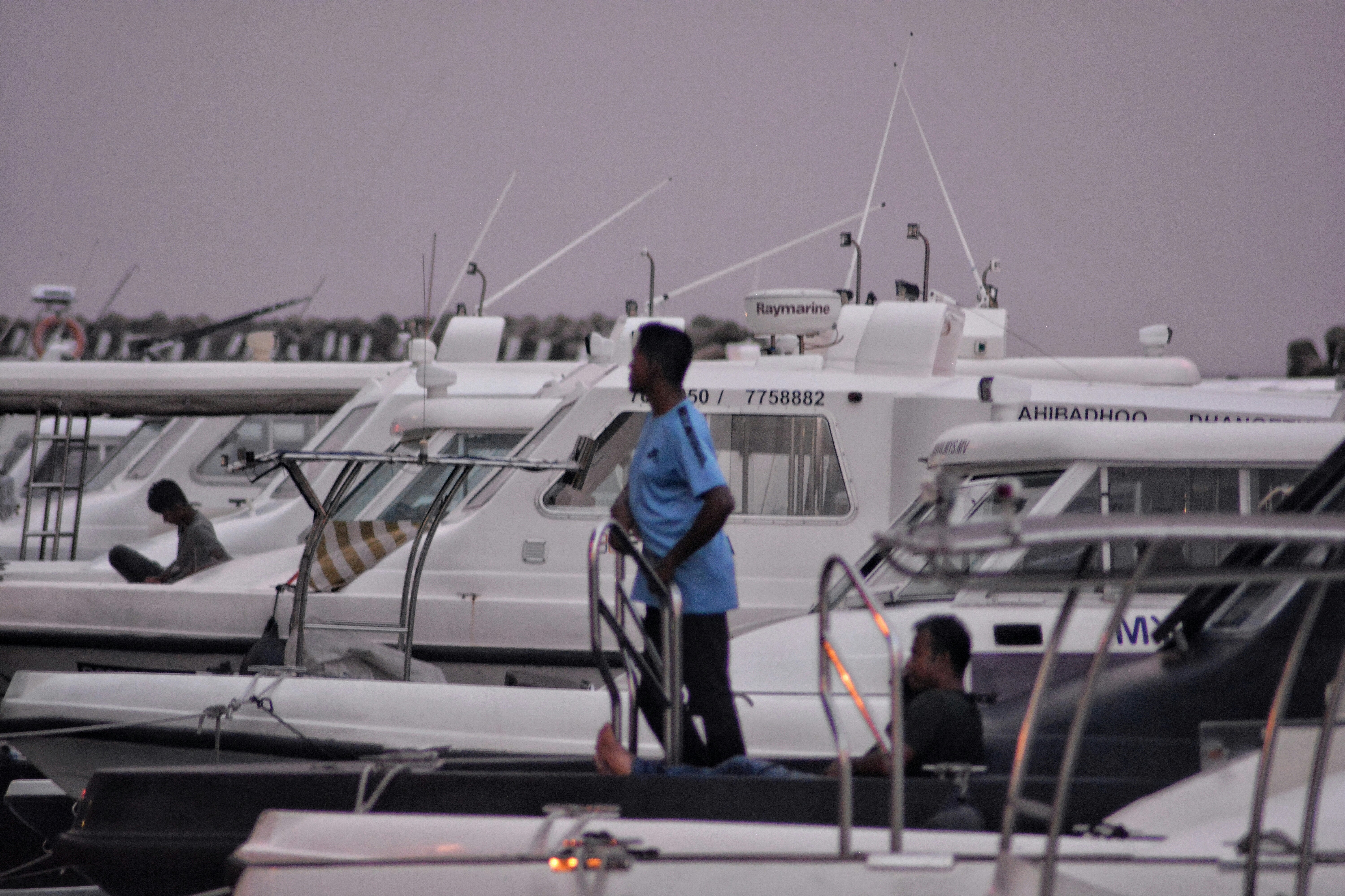 A man standing on a boat in a marina