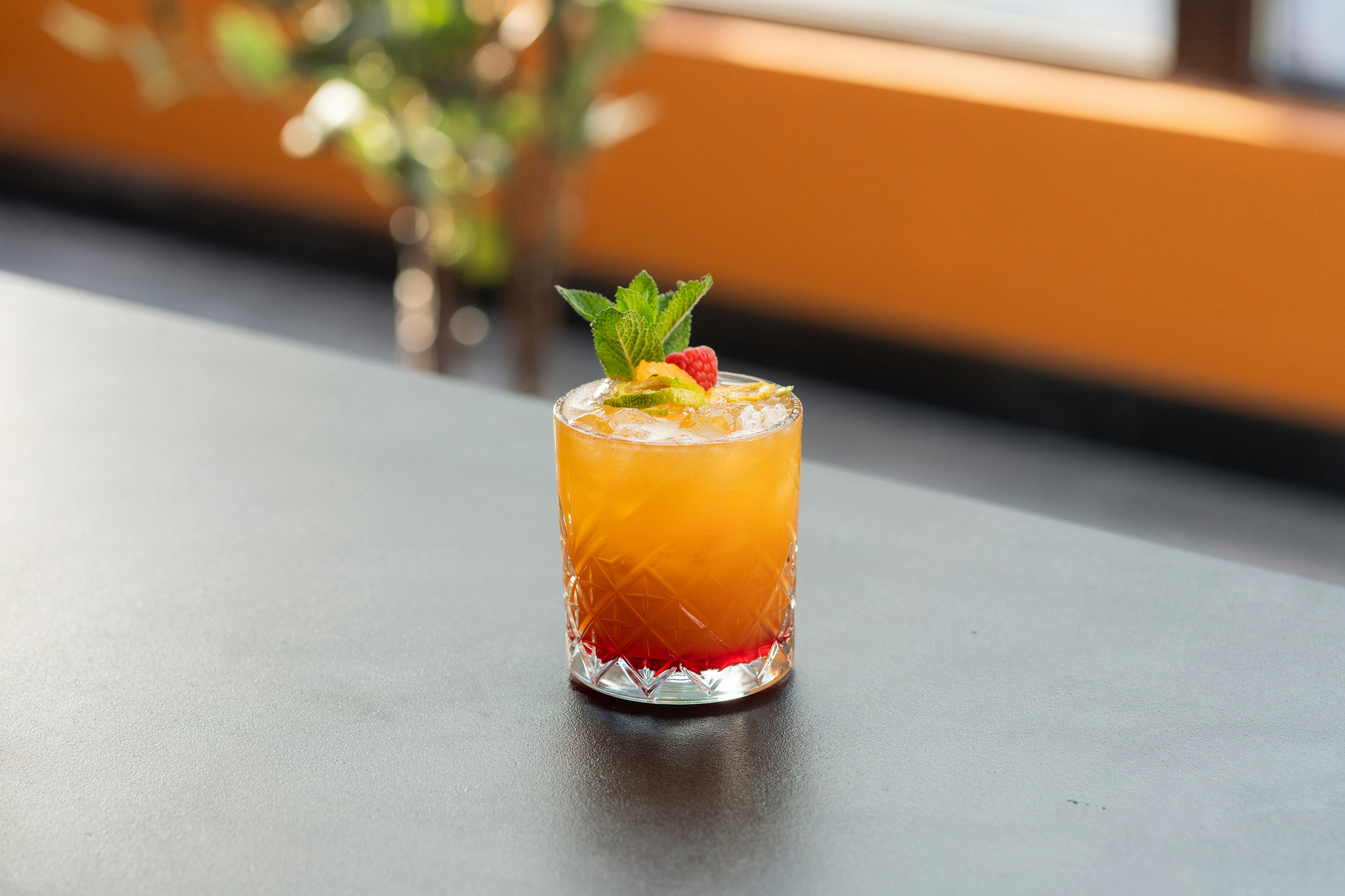 A drink sitting on top of a table next to a vase