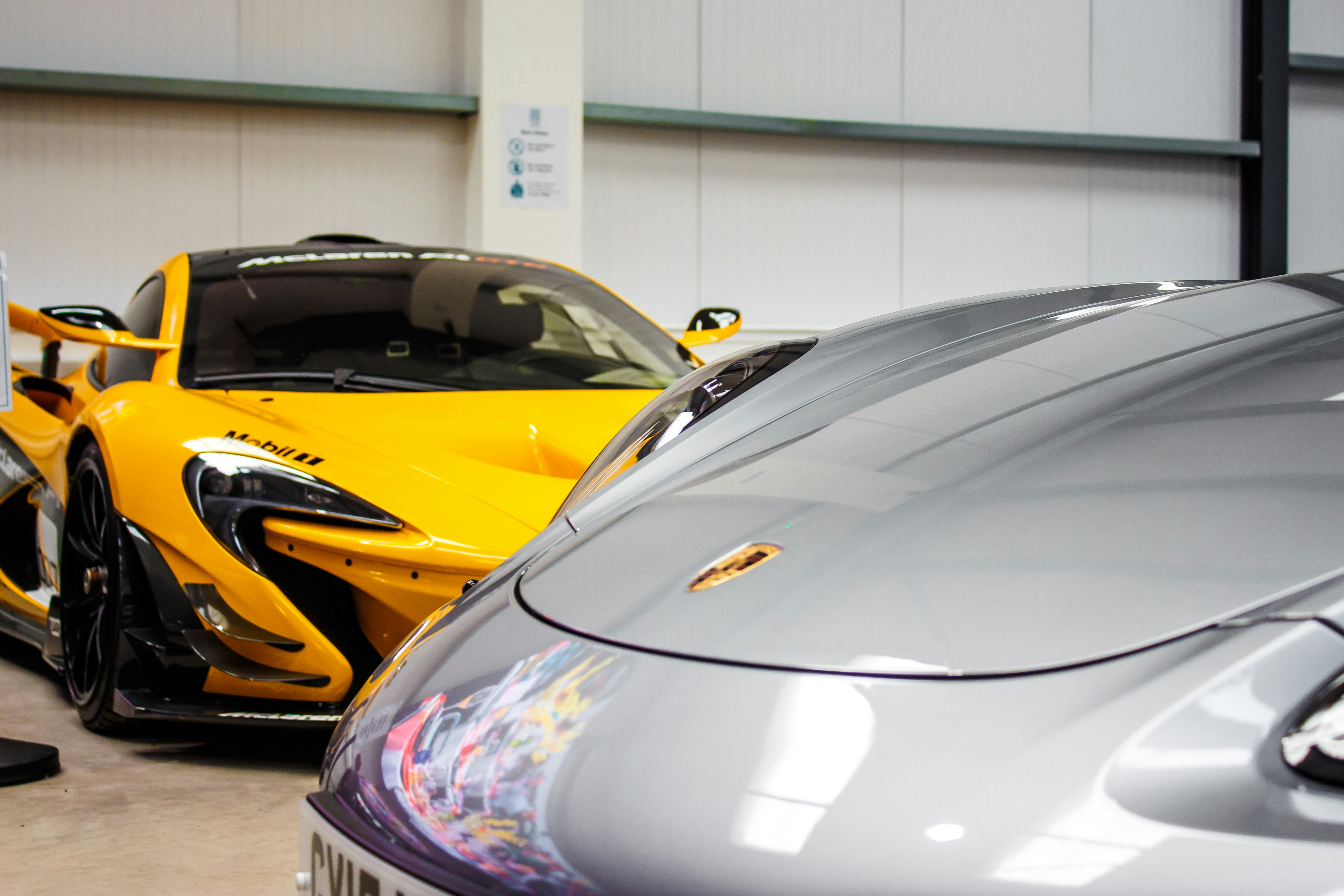 A couple of sports cars parked in a garage