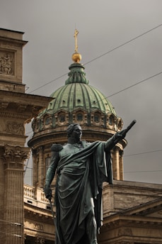 A statue of a man holding a gun in front of a building