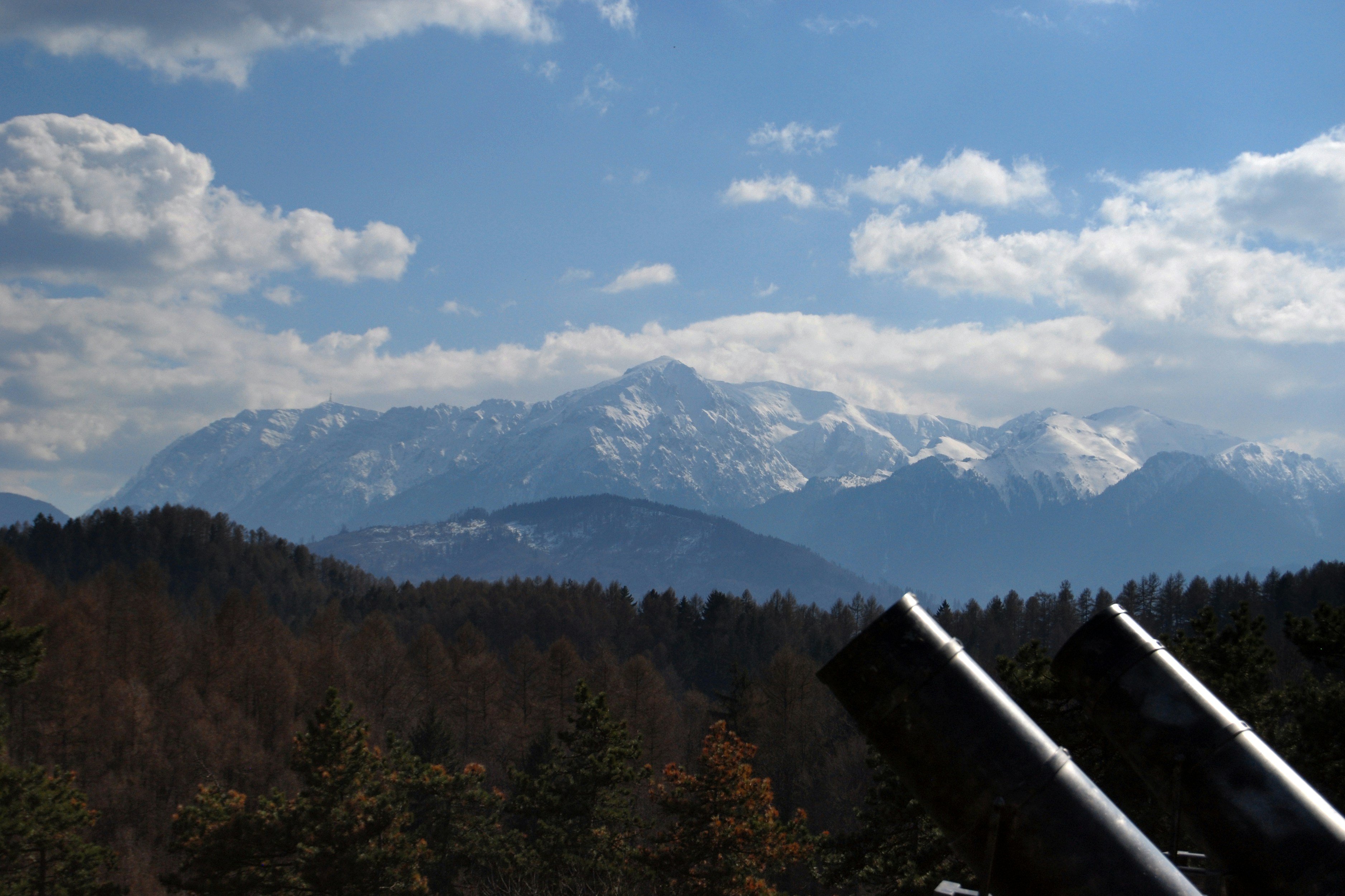 A telescope on a tripod with a mountain in the background