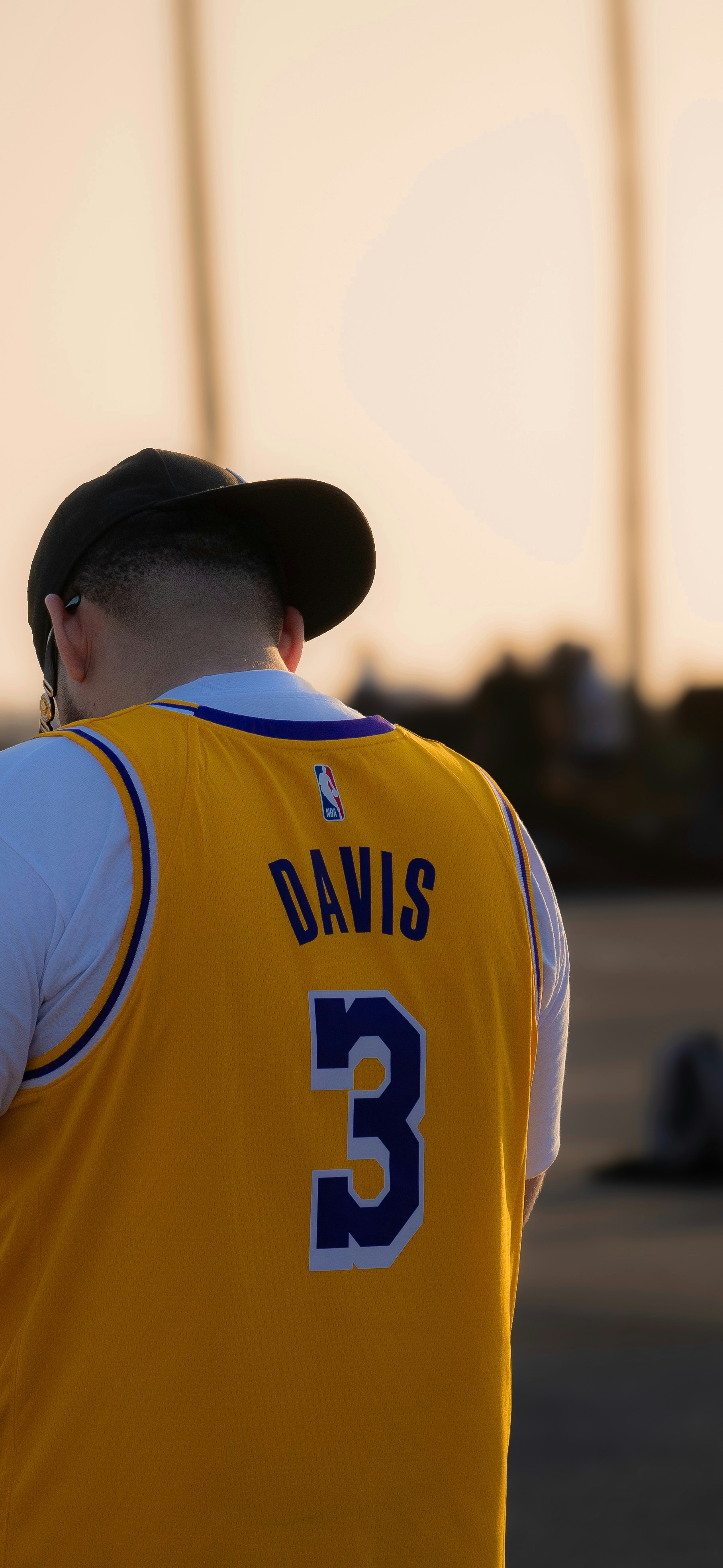 A man in a yellow jersey is standing in a parking lot